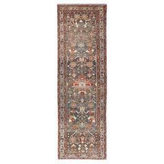 Antico runner in malayer con disegni geometrici in grigio, blu, rosso e marrone.