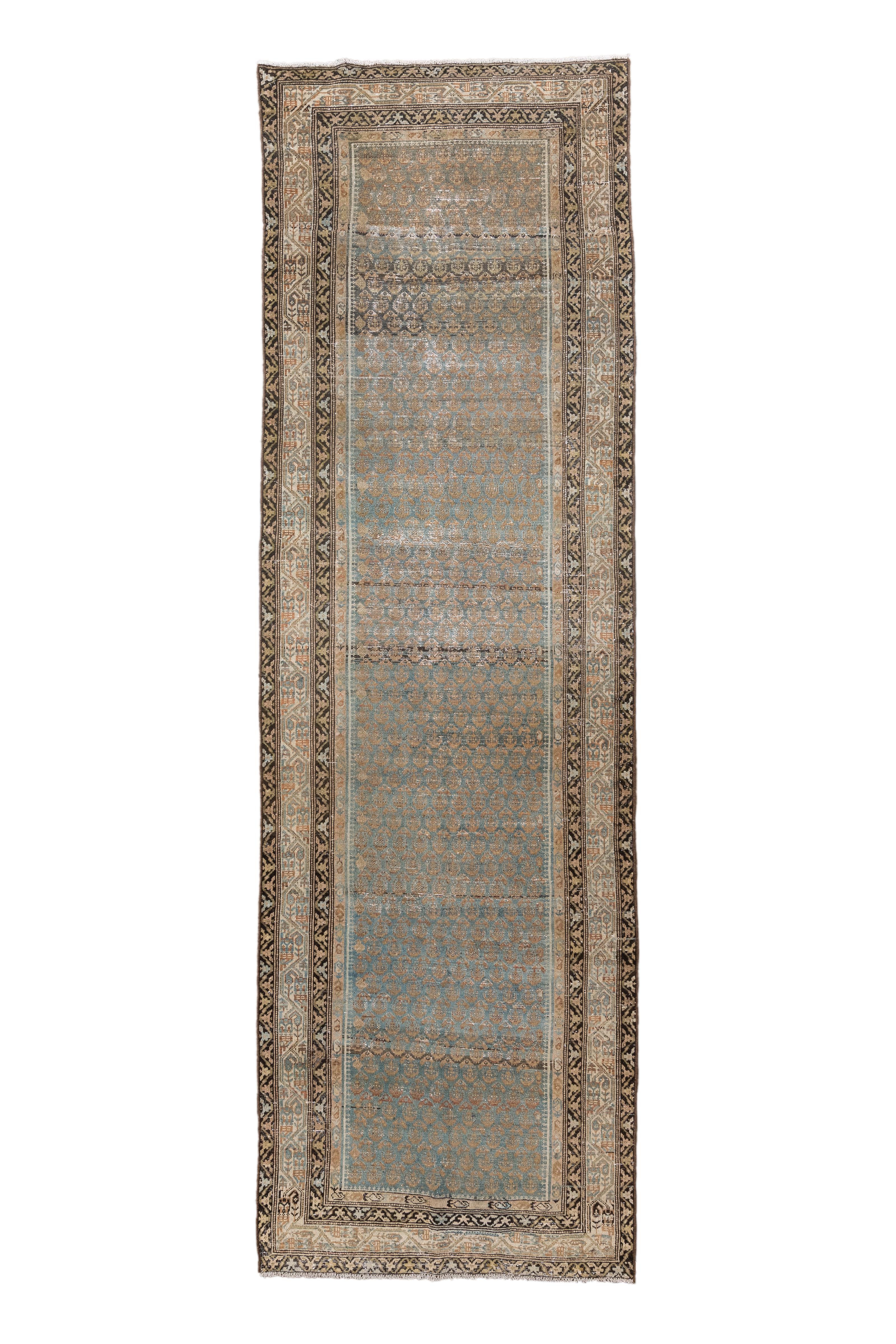 This antique Malayer runner features a refined Herati design rendered in soft hues of dusty blue, taupe, and walnut brown. A narrow central field is flanked by a series of intricate borders with stylized rosettes and scrolling vinework,
