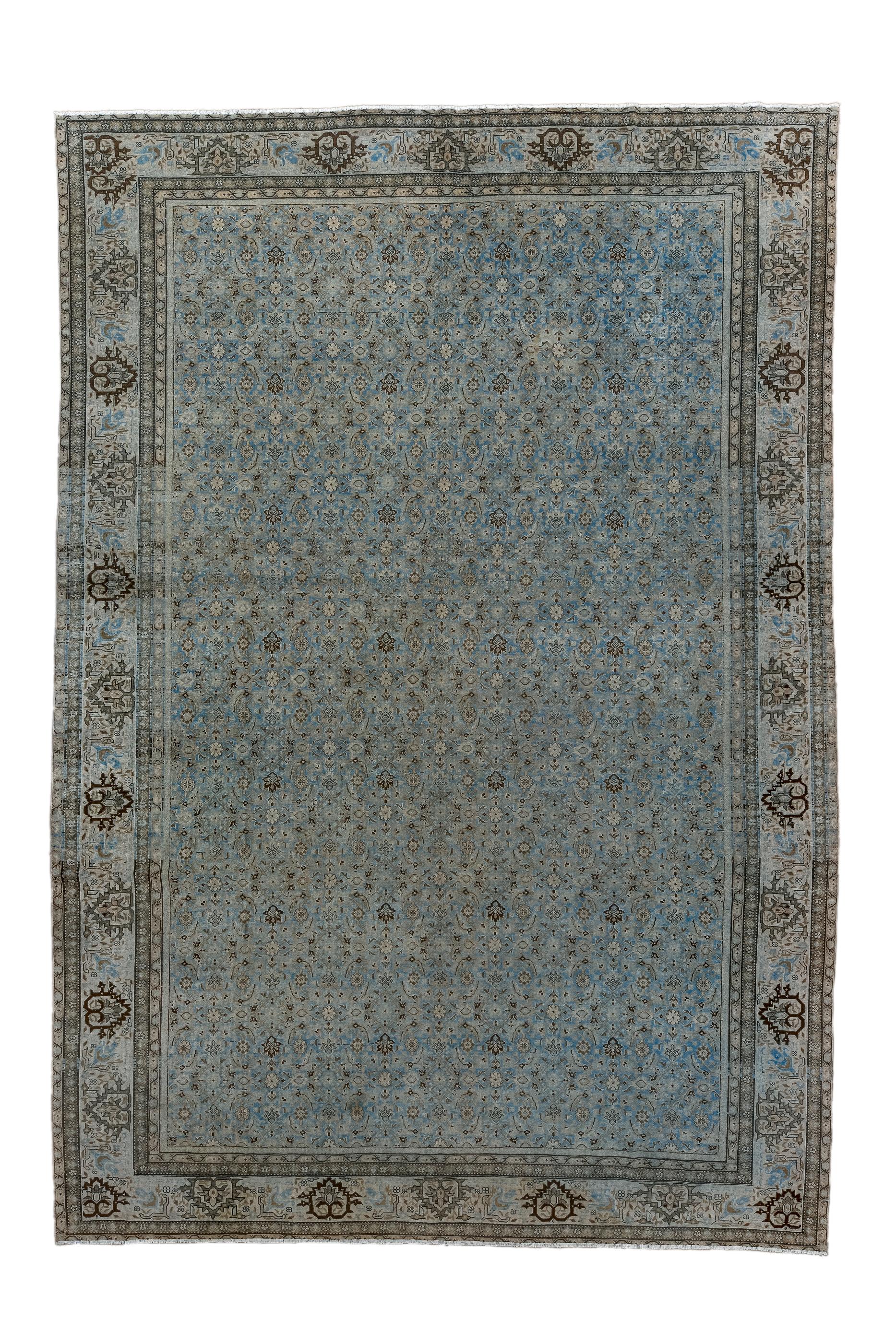 The light blue-grey ground supports a balanced small allover Herati design with ecru and near black occasional accents.  The sand border features reversals of ragged and partially stepped open palmettes. Good condition, moderate/medium weave, on