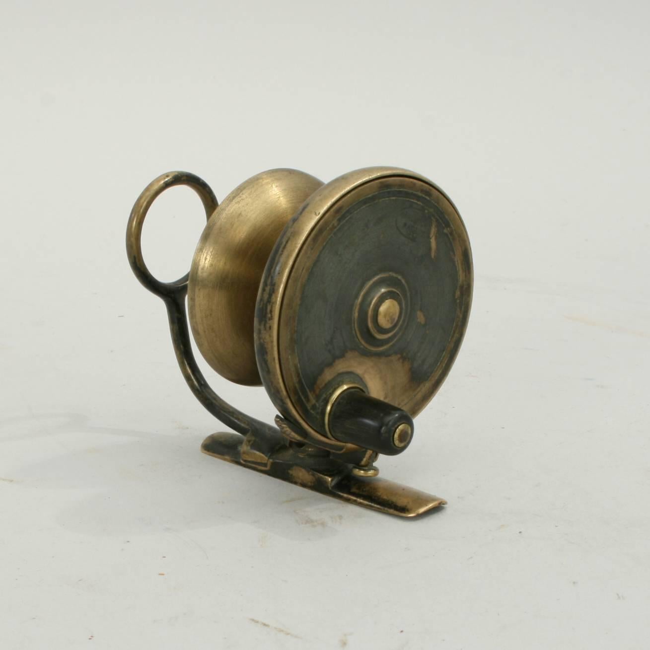 A rare sized (2.5') Malloch of Perth side casting fishing reel of fine quality and in excellent condition. The reel is all brass, with optional check, exchangeable drum and small black Horn handle. The large guide eye remains stationary on the fixed