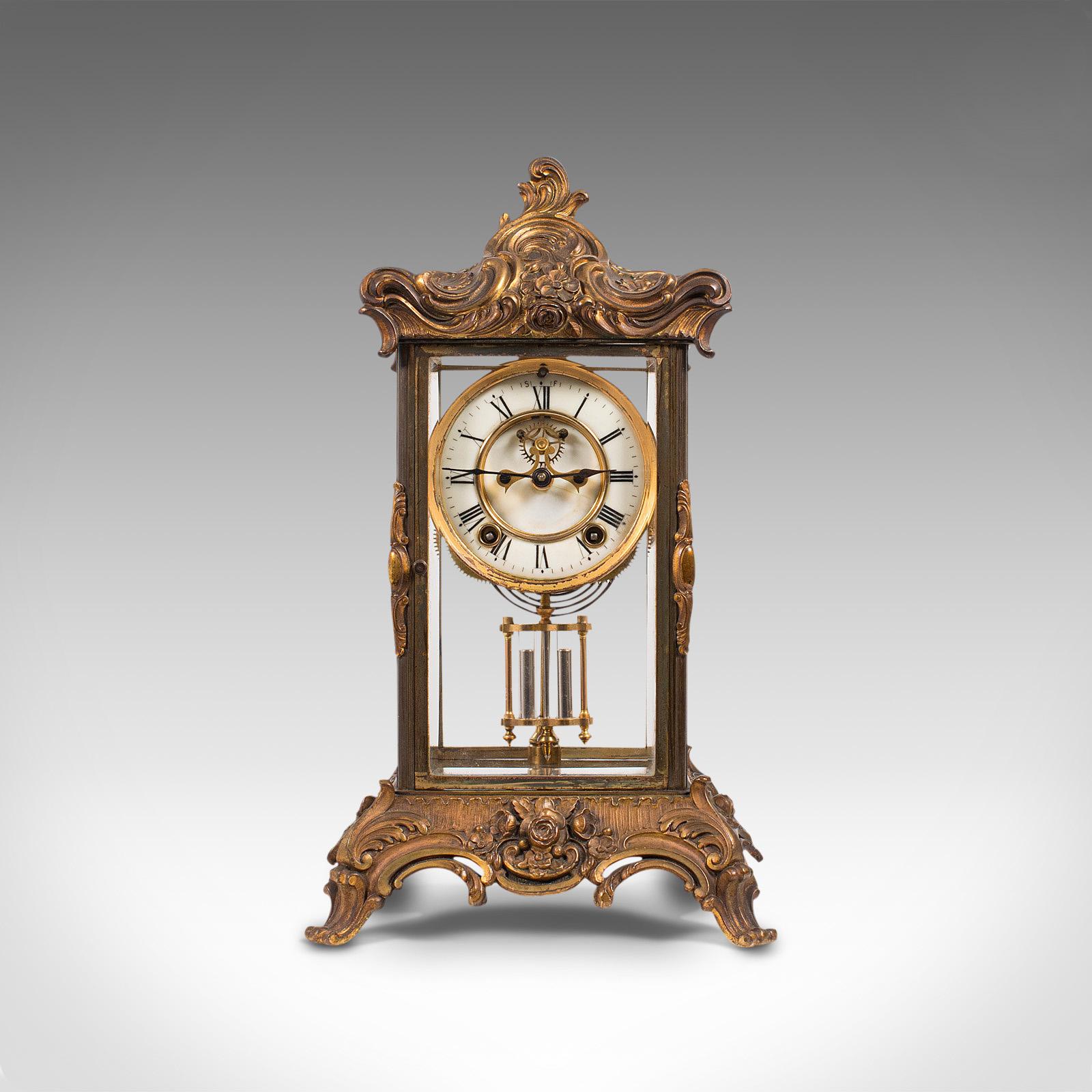 This is an antique mantel clock. A French, four glass, gilt bronze and ormolu decorated clock with visible Brocot escapement, dating to the late 19th century, circa 1900.

Superbly decorated timepiece for the mantel
Displaying a desirable aged