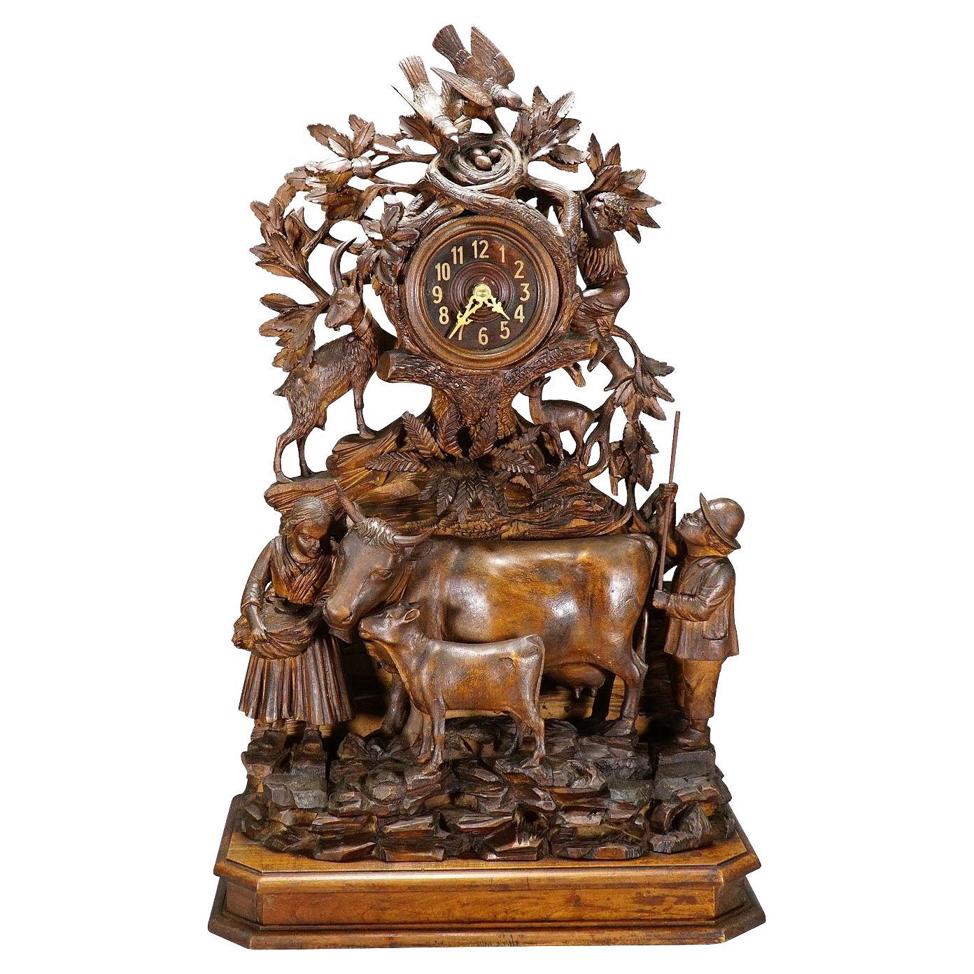 Pendule de cheminée ancienne avec famille d'horlogers, chèvres et bétail