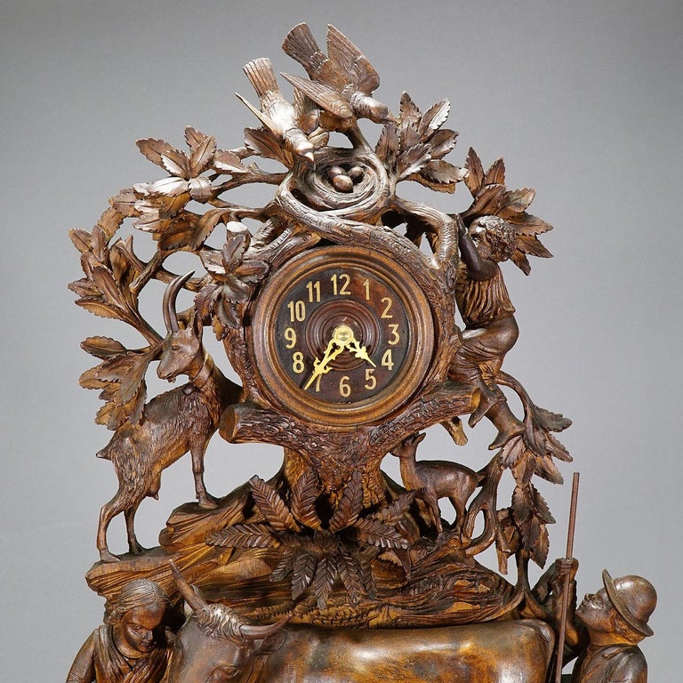 A Black Forest wooden carved mantel (fireplace) clock with a lovely herdsman family with their goats and cows. a masterpiece of woodcarving which brightens up any chimney piece. Clockwork replaced by battery driven one - working order.

Measures: