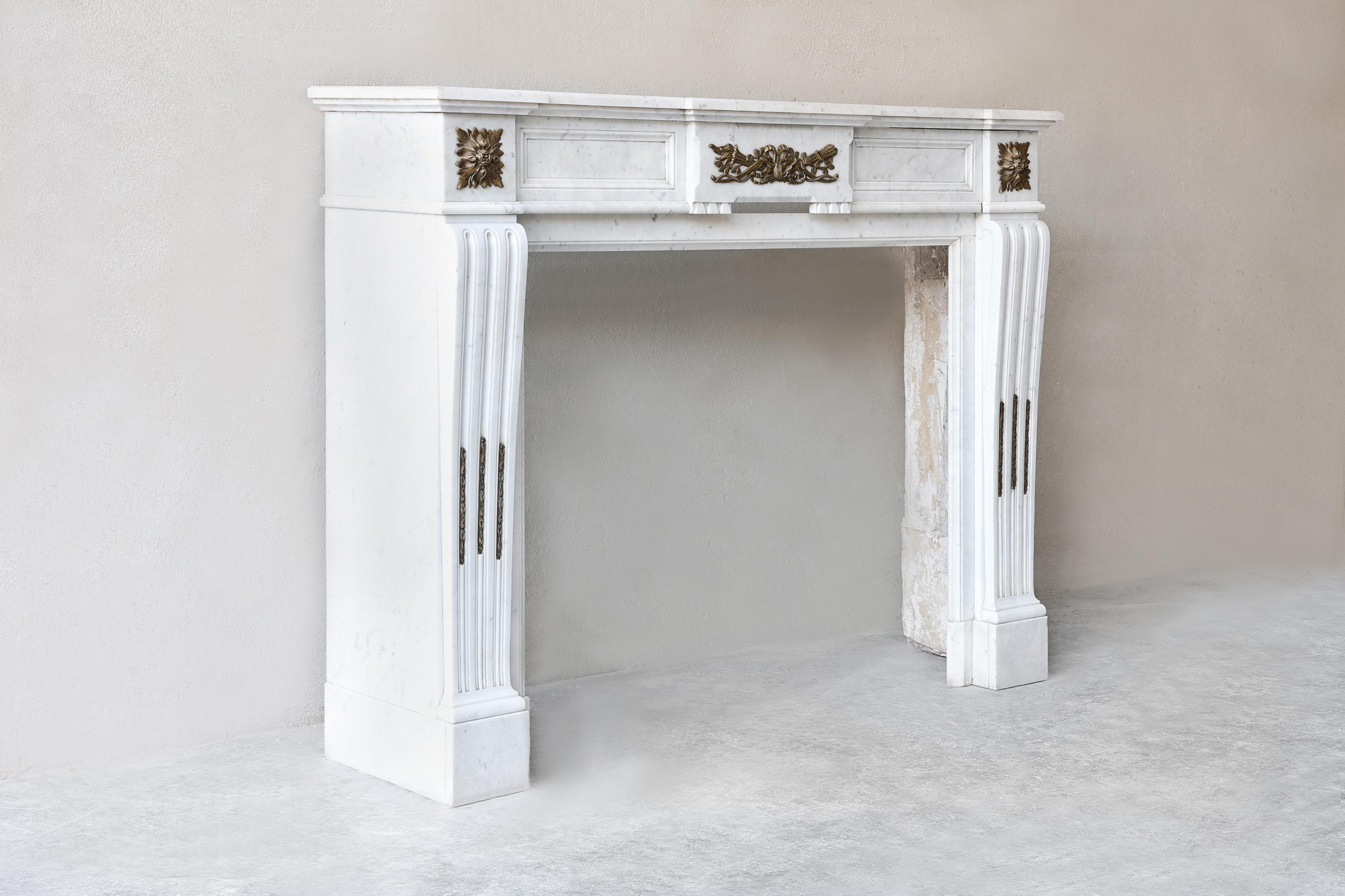 Bellísima repisa antigua ornamentada de mármol de Carrara con baño de oro del siglo XIX. Un verdadero punto de atracción en tu interior. Esta repisa de estilo Luis XVI está provista de adornos dorados en el frente, bellas líneas y estrías en las