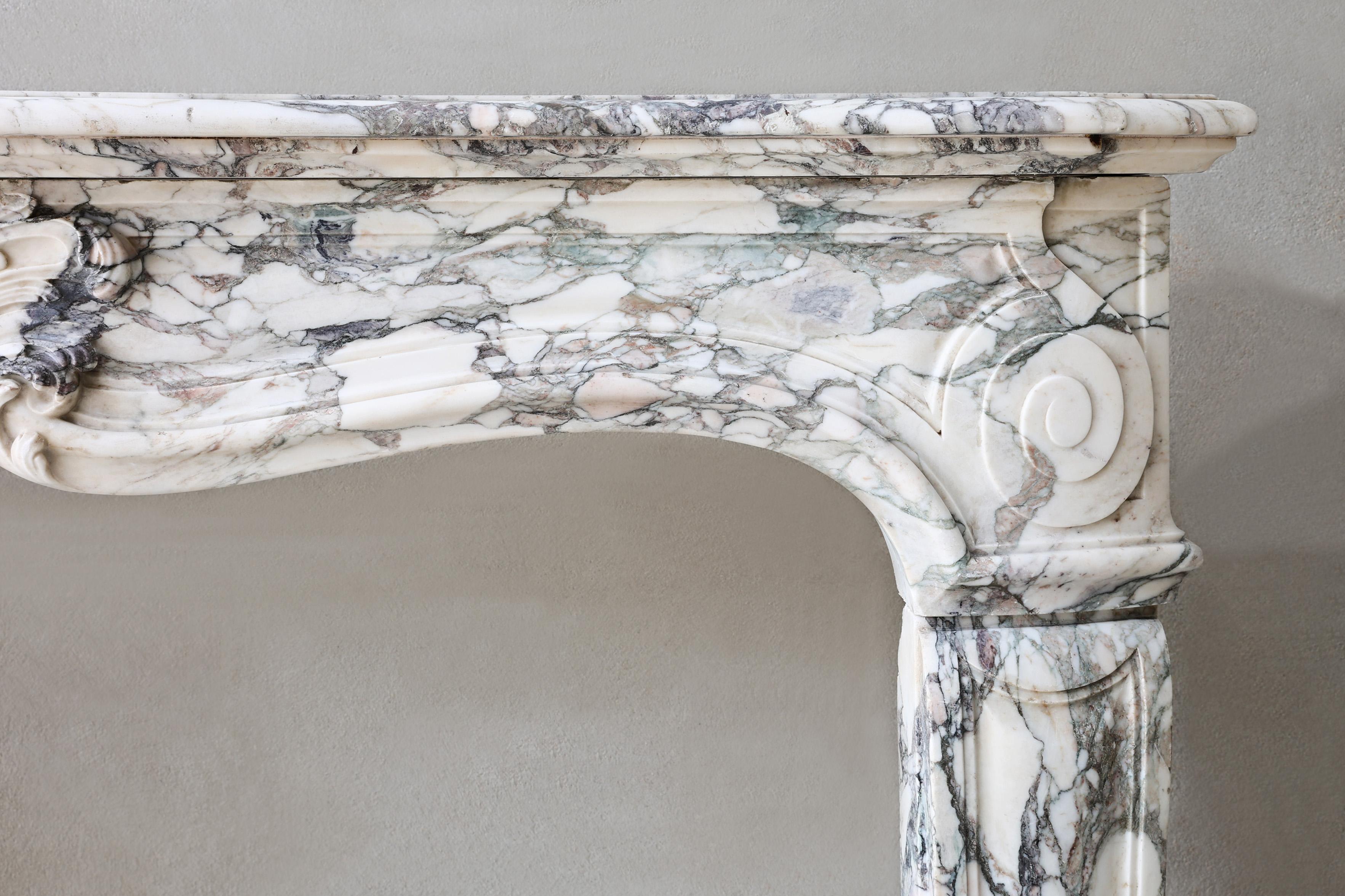 A One-of-a-Kind 19th Century French Marble Mantel

This antique marble mantel from 19th-century France is a fine example of the Louis XV style, celebrated for its flowing curves and ornate symmetry. Crafted from Paonazzo marble — a rare and