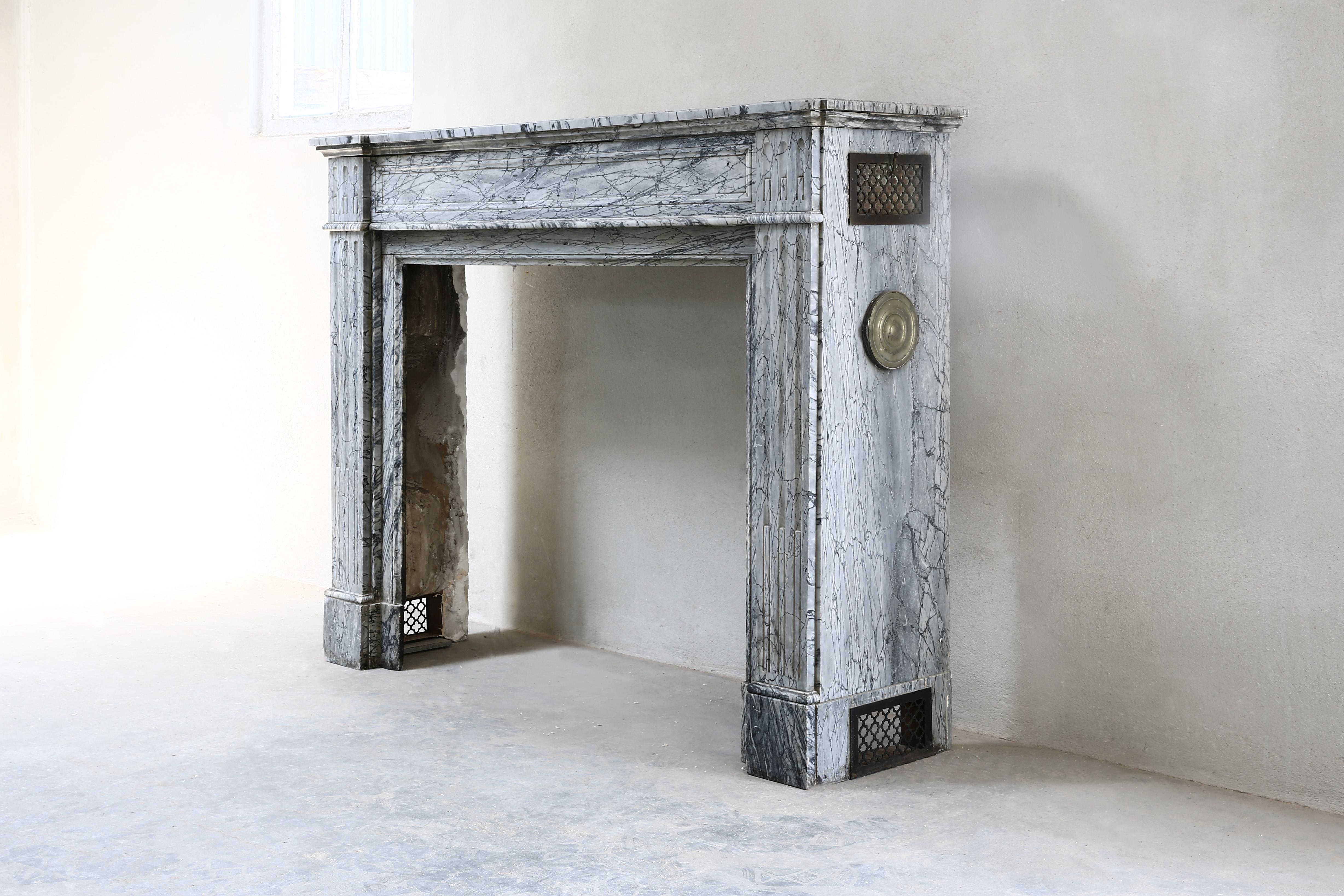 Beautiful antique fireplace of Blue Fleuri marble from the 19th century. This fireplace is in Louis XVI style and has straight shapes. Blue Fleuri marble is a type of marble that was widely used for fireplaces from the 19th century. Nice to mention