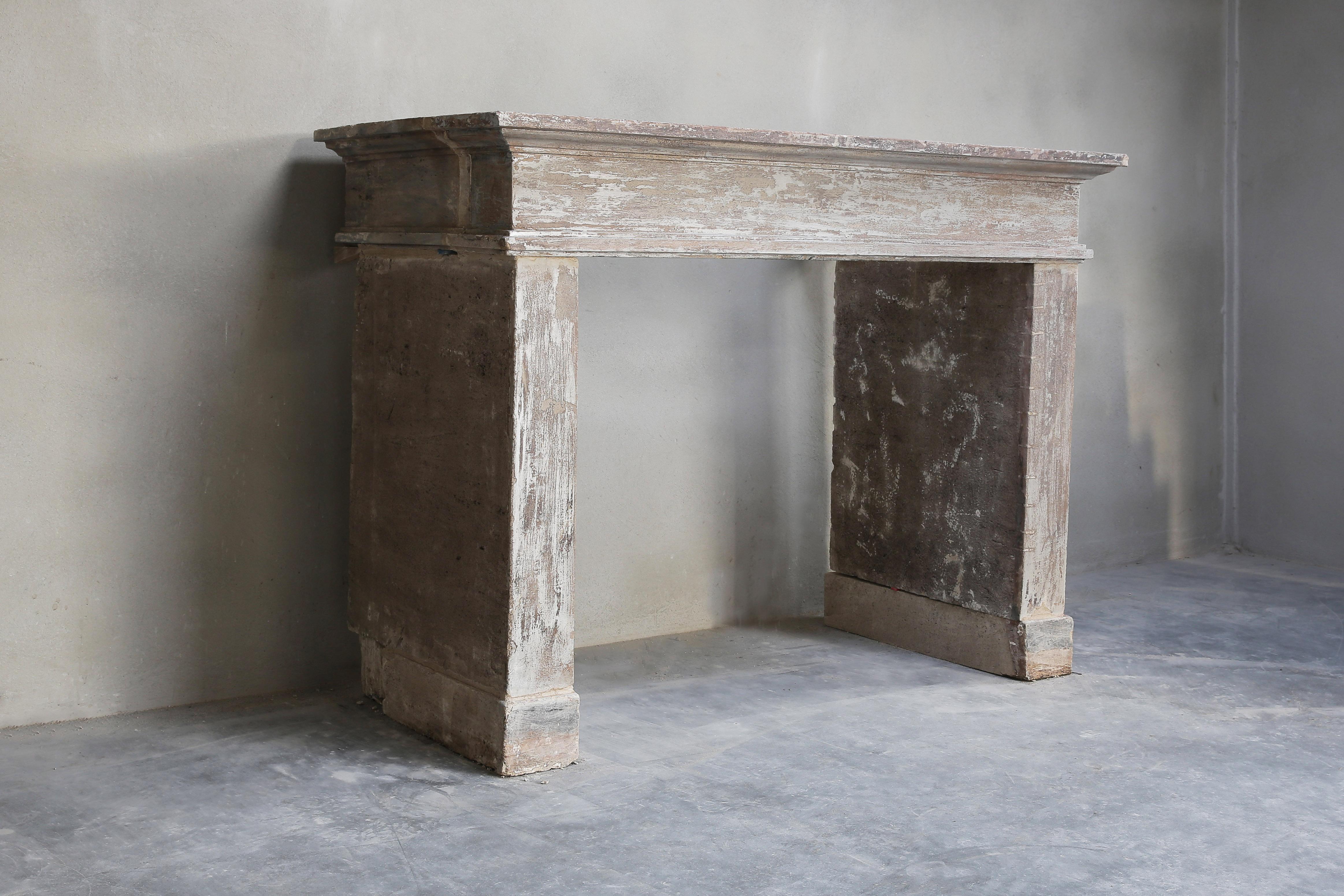 Sober and simple antique mantelpiece made of French limestone from the 19th century. Robust due to the front top and straight legs. The chimney is patinated and gets an authentic rural look. A very nice fireplace that fits perfectly within a rustic