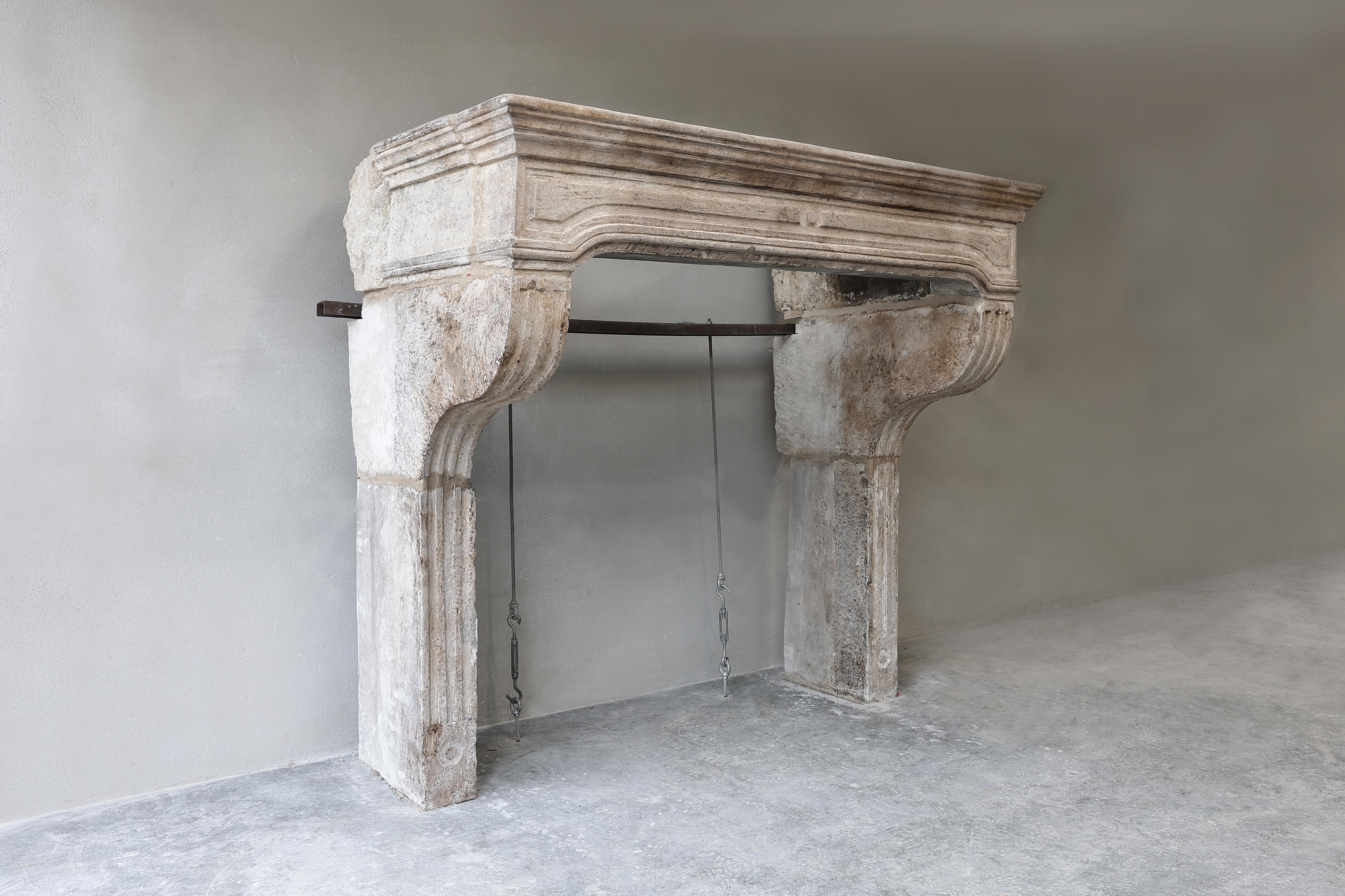 Imposing antique castle mantelpiece of French limestone in the style of Campagnarde. This robust mantelpiece dates from the 19th century and has beautiful fluting on the legs and beautiful lines in the top. A stately chimney with a warm color scheme!