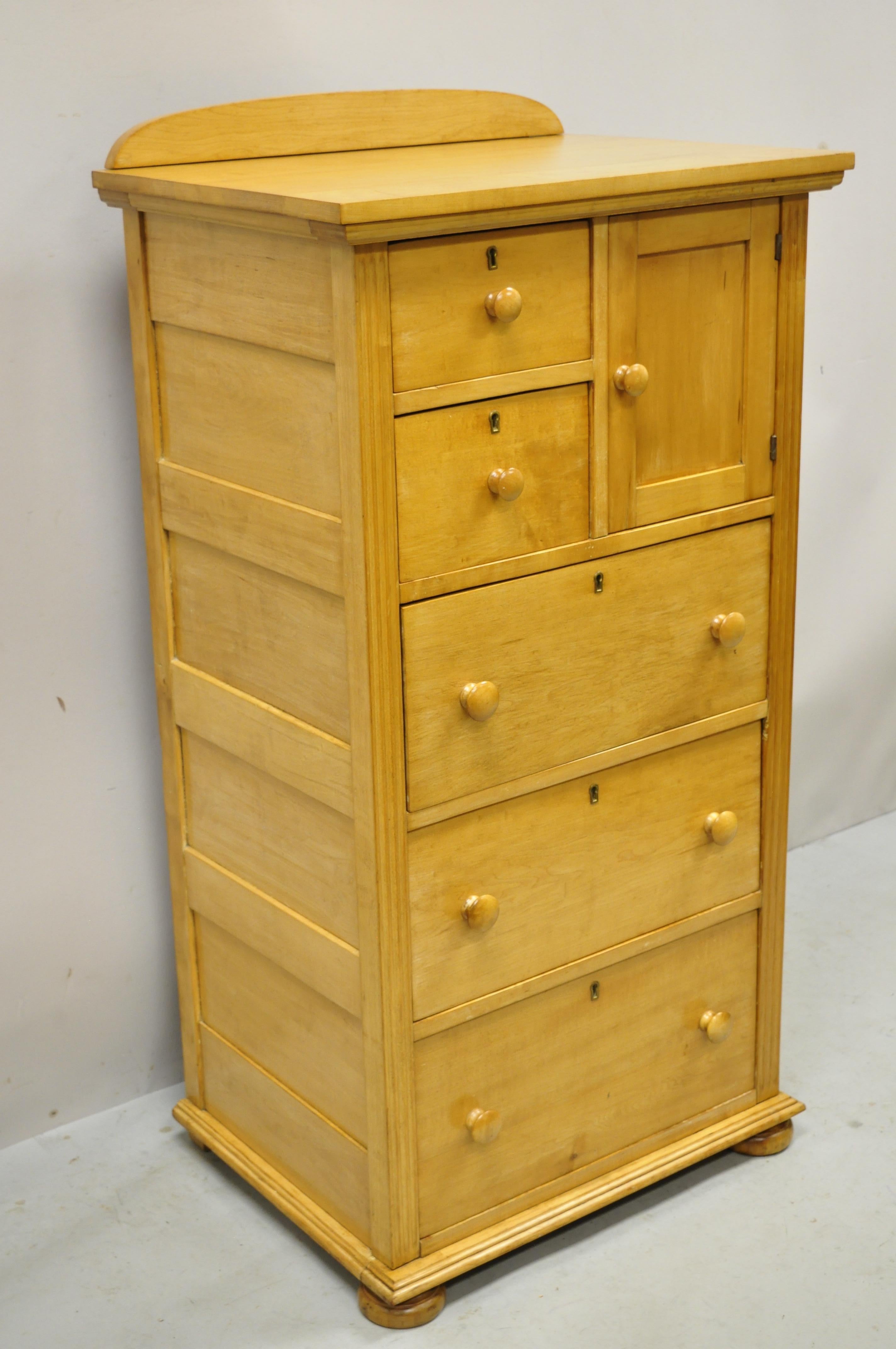 Antique maple wood American Empire tall chest washstand dresser. Item features bun feet, panel back and sides, backsplash, solid wood construction, beautiful wood grain, 1 swing door, no key, but unlocked, 5 dovetailed drawers, very nice antique