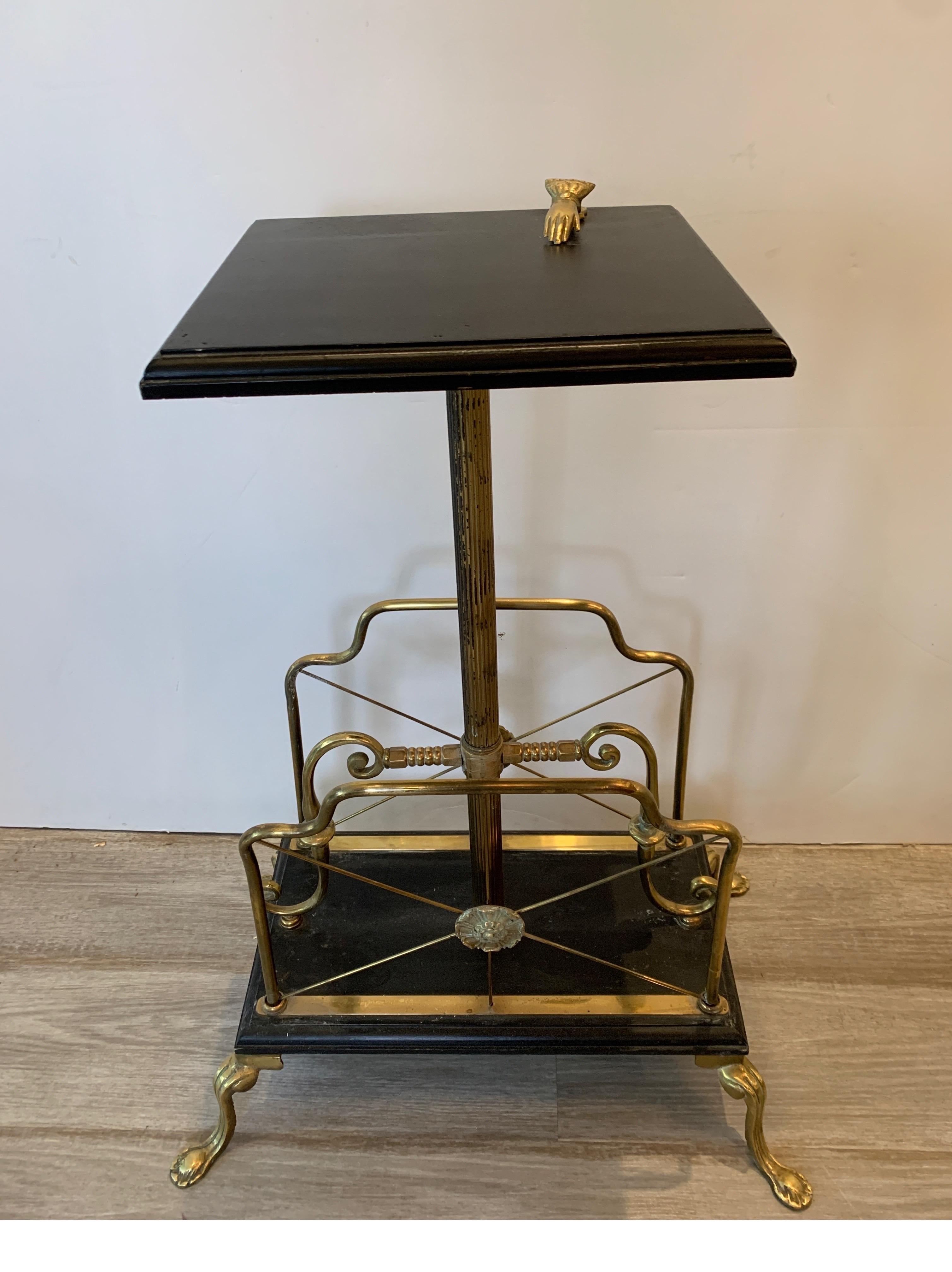 Charming Victorian magazine stand or music holder. The brass and dark green marble top with an upper table surface with an attached clip to hold things in place. The bottom with two places for storing papers and books.