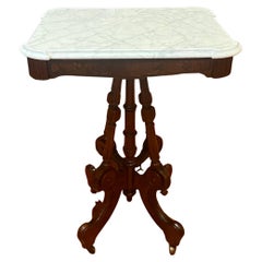 Ancienne table de salon en marbre et acajou sculpté sur roulettes