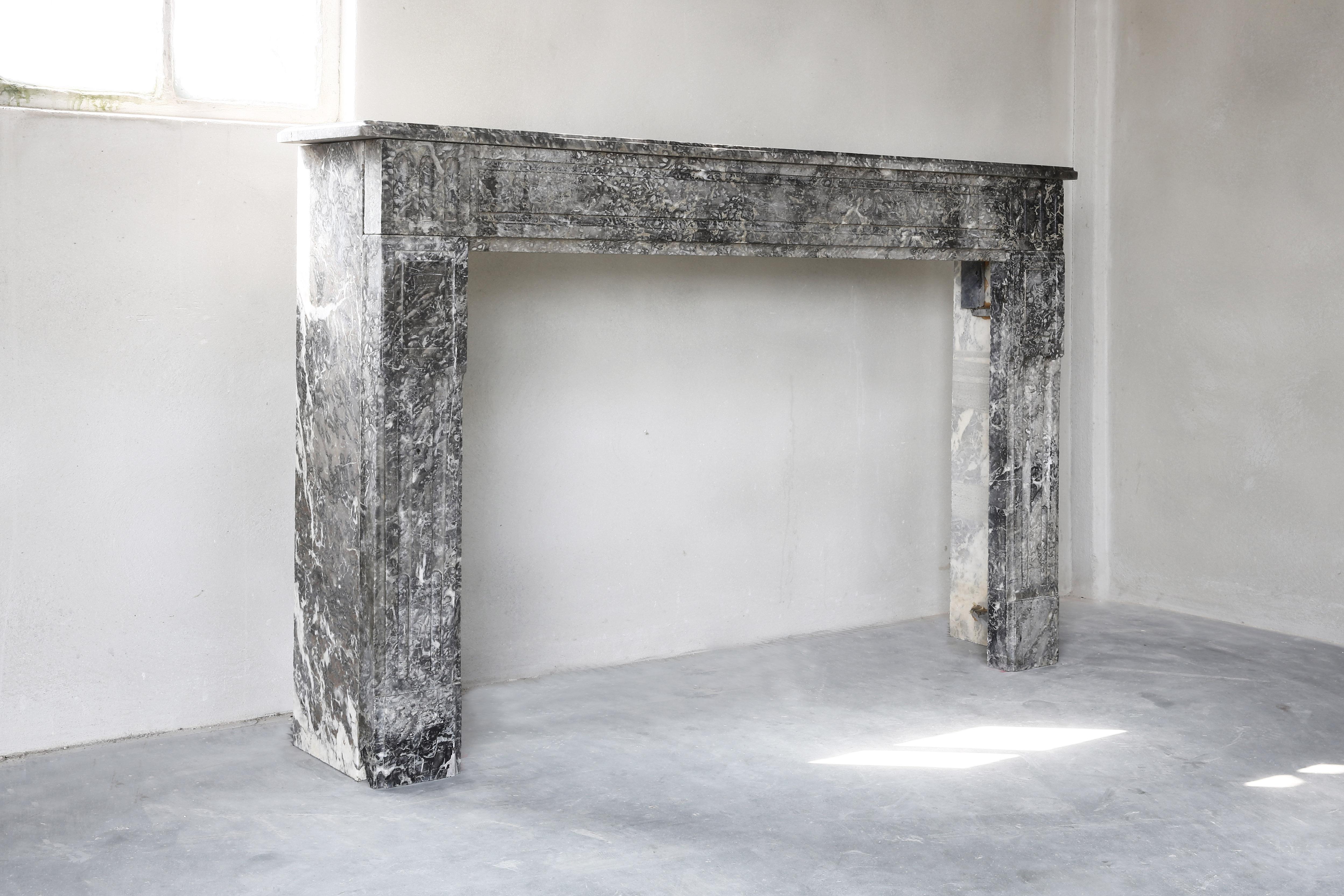 Beautiful straight antique fireplace made of marble. The marble type is St. Anna and is originally from Belgium. It is a beautiful type of marble, especially if you look at the fireplace on close-up! A part of the top and the legs are provided with