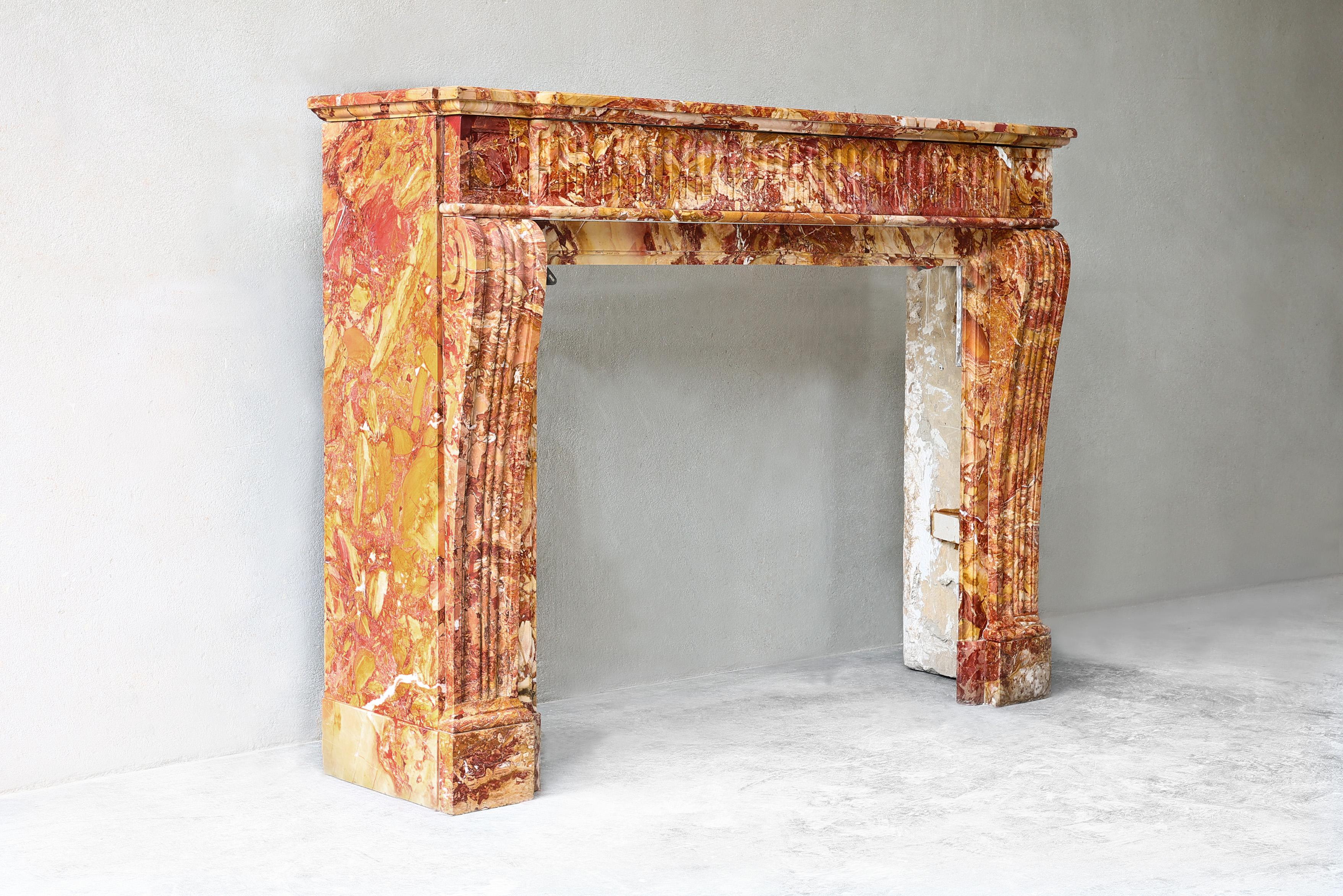 Beautiful colorful antique fireplace of Breche de Saint Maxim marble. This mantle dates from the 19th century and has beautiful hand-cut processing in the front part of the fireplace and on the legs! A fireplace with allure and appearance and, due