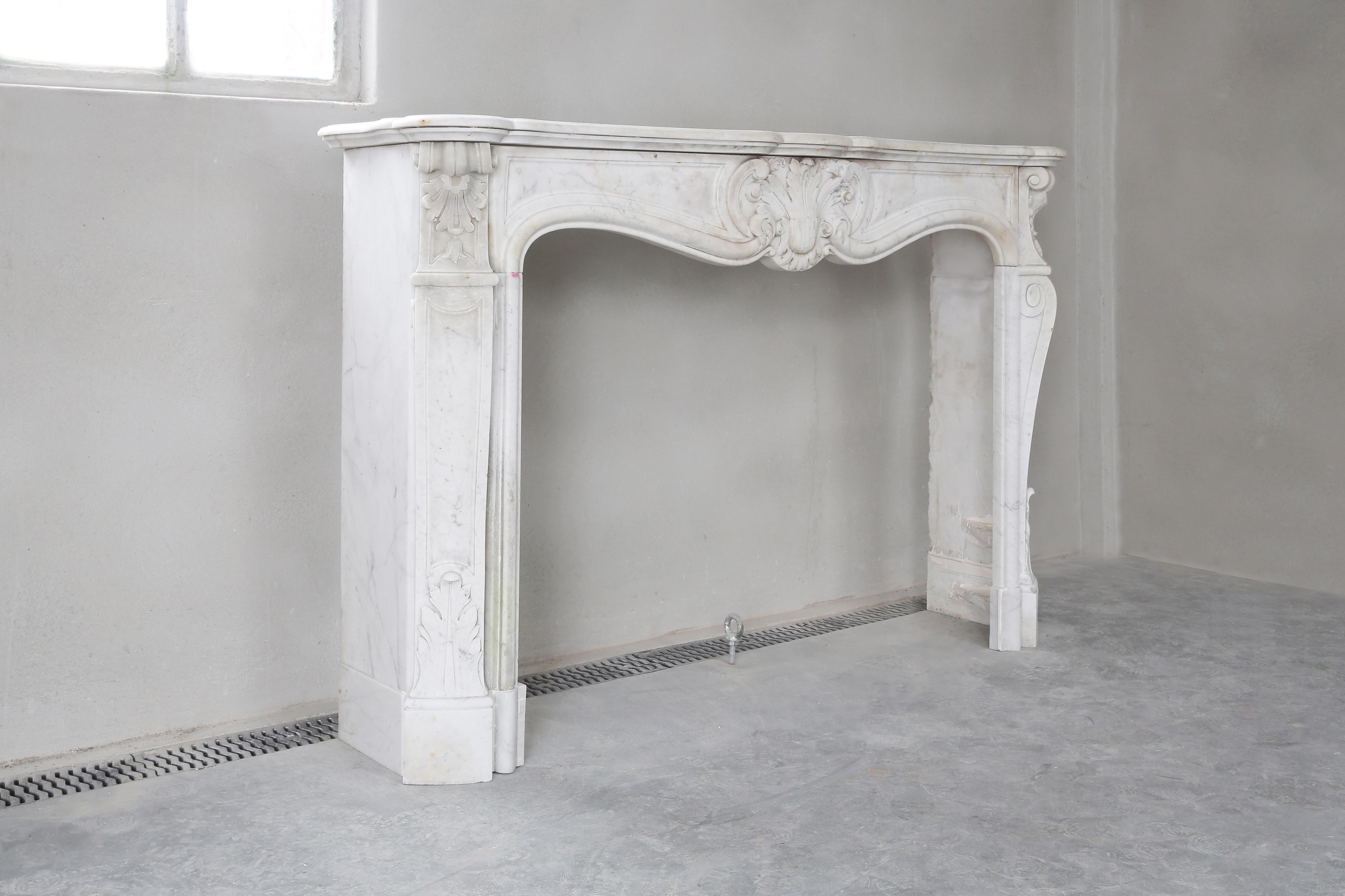Elegant white antique marble fireplace from Carrara marble. Carrara marble is extracted from Italian grooves and is a beautiful natural product! This mantelpiece dates back to the 19th century and is entirely in the style of Louis XV. Equipped with