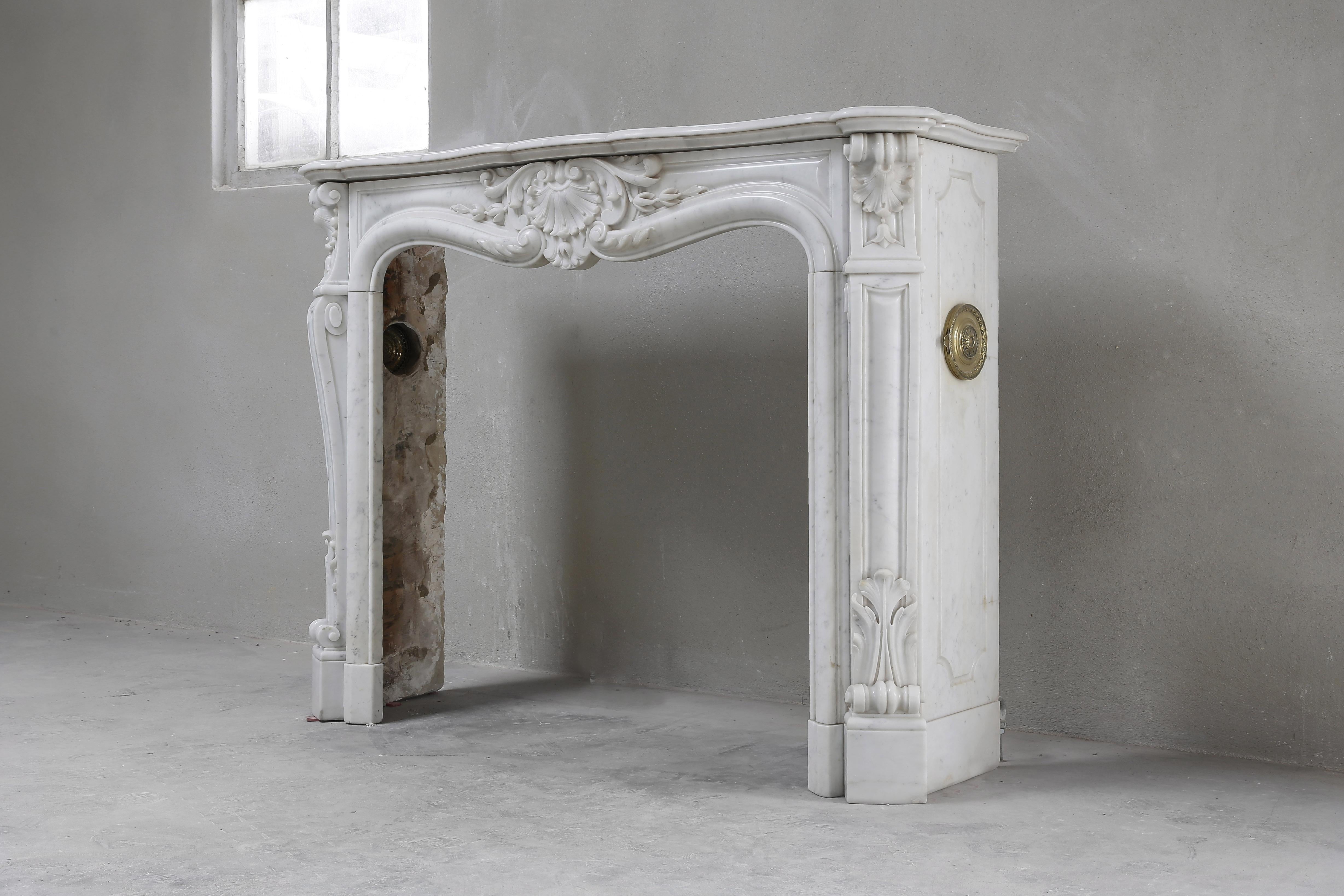 Very beautiful white marble mantelpiece from the 19th century, in the recognizable style of Louis XV. A beautiful fireplace with many decorations of the Italian marble variety Carrara. Carrara is a town in Italy and is also called the city of the