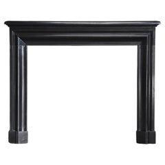 Antique marble fireplace of Noir de Mazy marble in style of Louis XVI