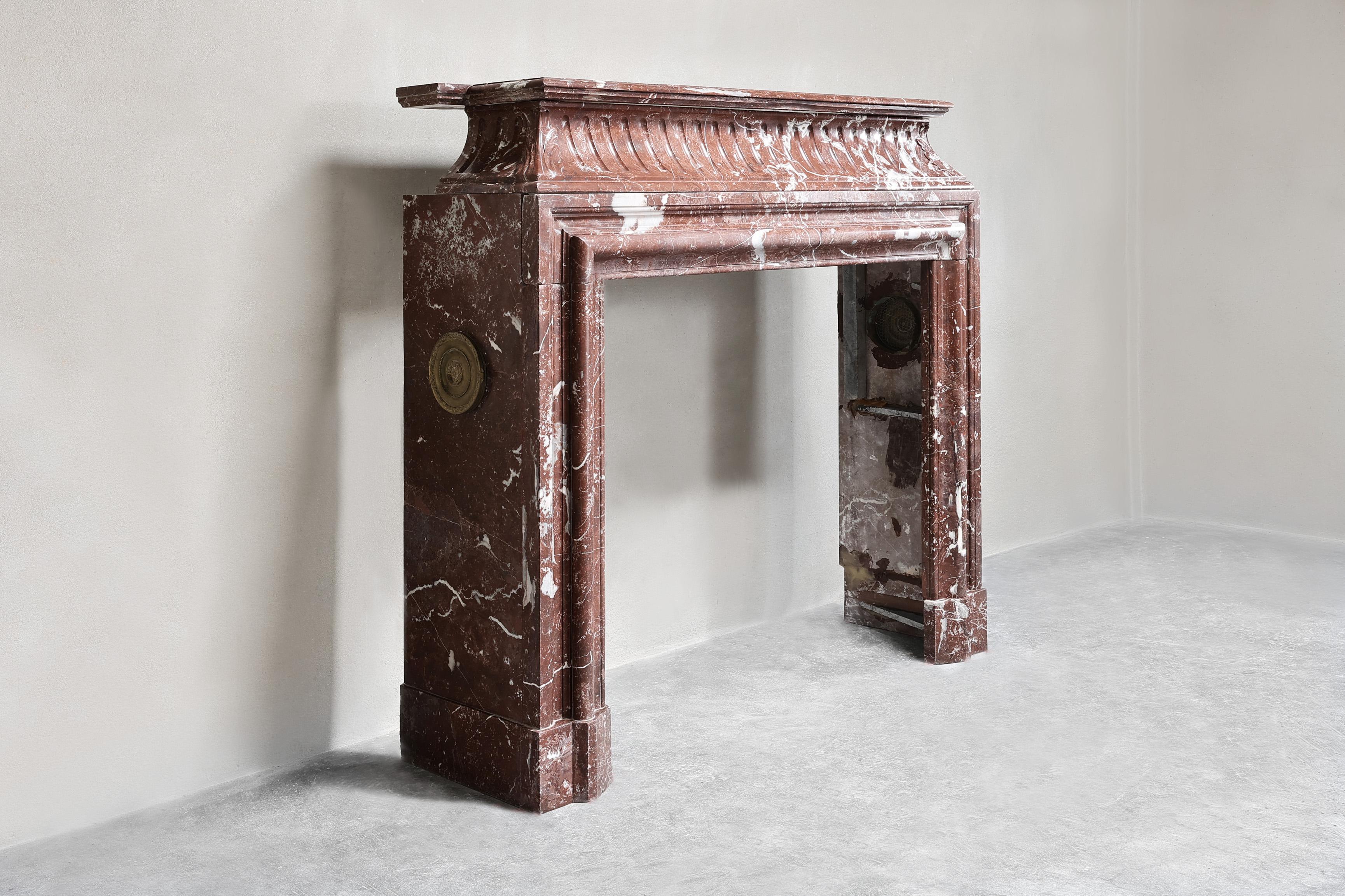 Beautiful antique mantelpiece made of Rouge Royal marble. This warm color scheme creates a lot of atmosphere and appearance! A unique fireplace within our collection from the 19th century in the style of Louis XVI.