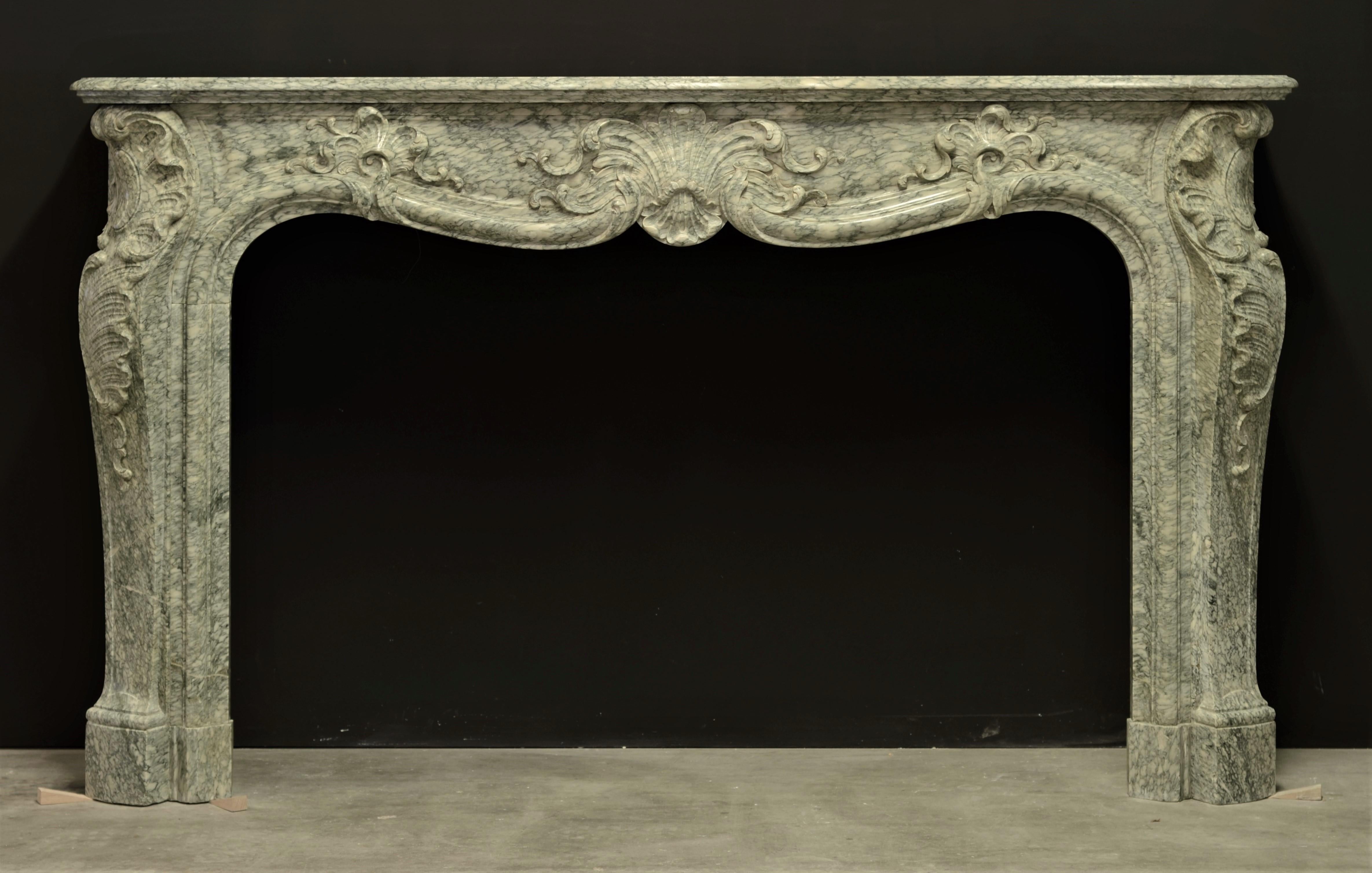 Beautiful decorated French Louis XV fireplace mantel in Vert d'Estour marble.

This nice proportioned mantel is made from soft green and ivory toned marble, this marble is can be found near the city of Moulin Lango in Seix in the
