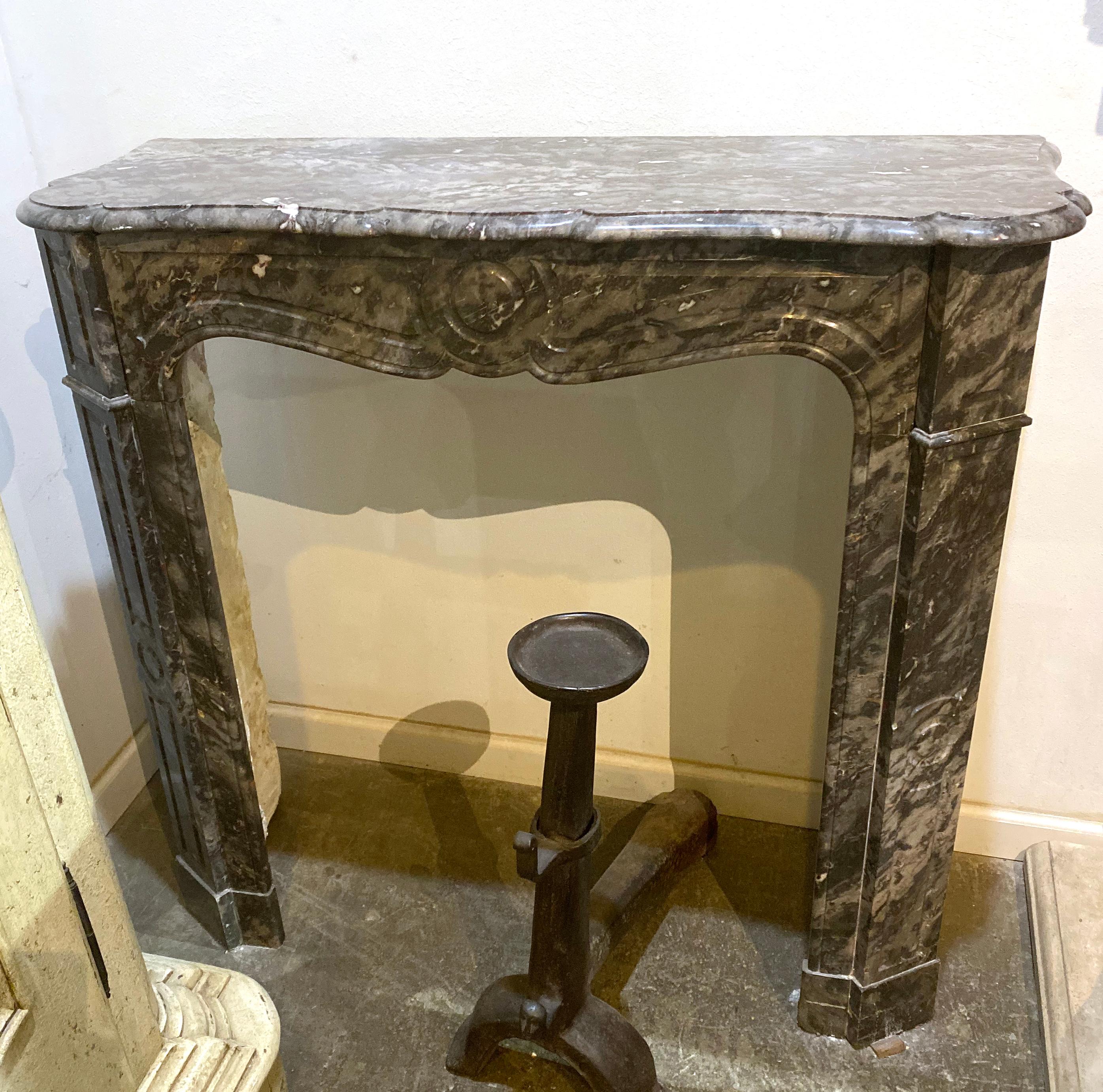 This French marble mantel features grey, white, and red veined coloring, and is carved in Pompadour style. Originates from France, circa 1860.

Dimensions: 41” W x 13.5” x 40.15” H
Firebox: 27.5” W x 33.5” H.