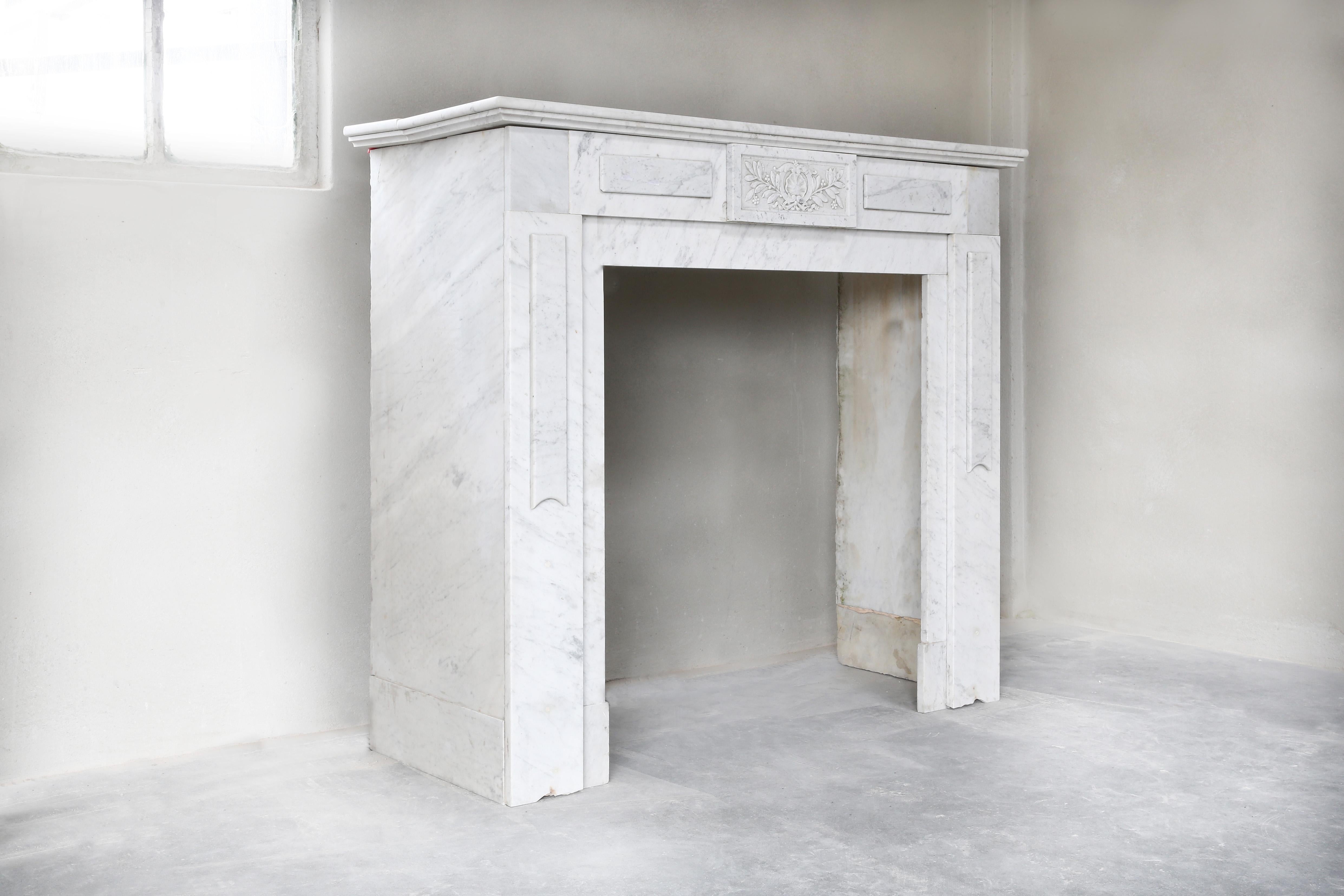 Antique white Carrara marble fireplace from the 19th century. Carrara marble comes from the Italian quarries of the city of Carrara. A beautiful white marble that is used for many applications. This fireplace is in the style of Louis XVI and has