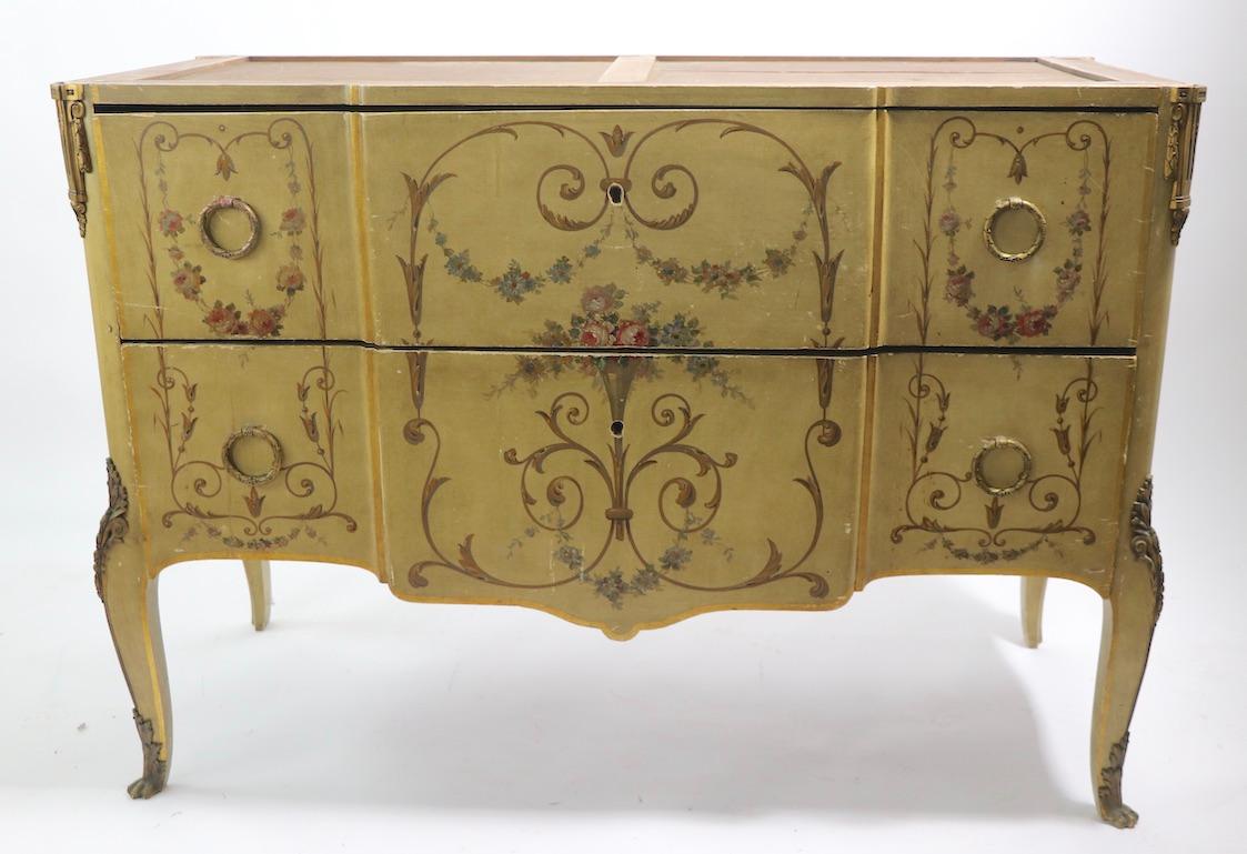 Affascinante comò con piano in marmo con decorazioni in vernice e finiture in bronzo ormolu. Riteniamo che questo esemplare sia del XIX secolo, forse di origine italiana o francese. La cassettiera ha due cassetti profondi, il suo piano originale in