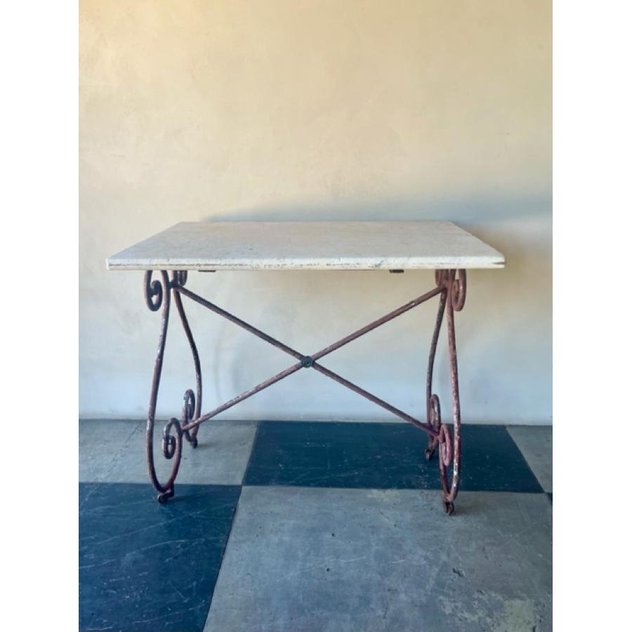 Antique marble top table, with scroll base and small casters and wheels. Some chips and stains on the marble top. Base painted red, with patina and rust. 

Item #: FR-0226

Material: Marble
Dimensions: 38.5