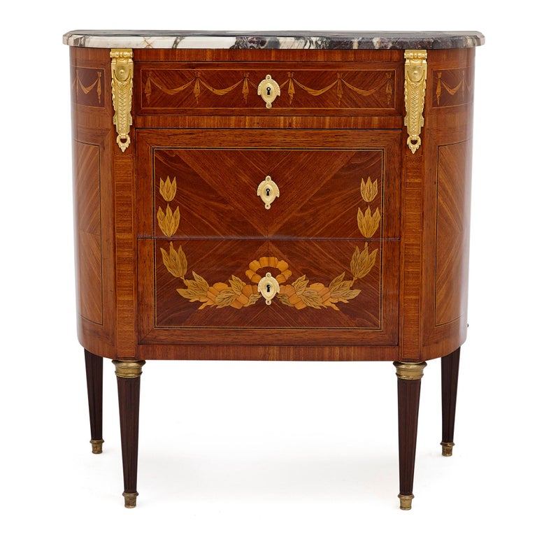 Antique marble topped hardwood dresser with neoclassical marquetry.
French, late 19th century
Dimensions: Height 85.5cm, width 79cm, depth 40cm

Designed in the elegant Neoclassical style, this 19th Century commode dresser is crafted from