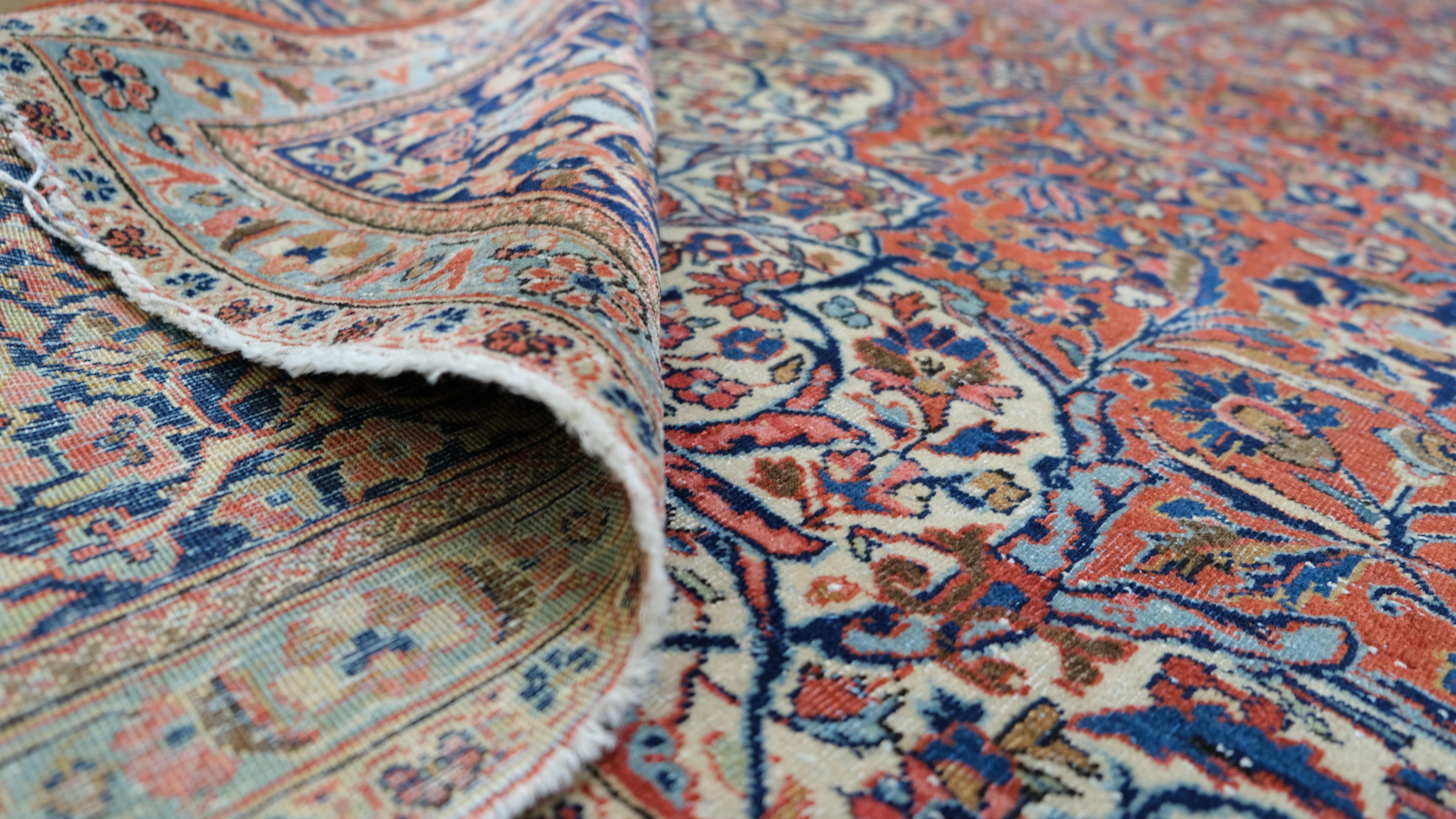 This stunning antique  hand-knotted wool rug features a grand floral medallion design, surrounded by intricate botanical and nature-inspired motifs. The deep crimson field is accentuated by complementary hues of ivory, navy, maroon, and soft pastel