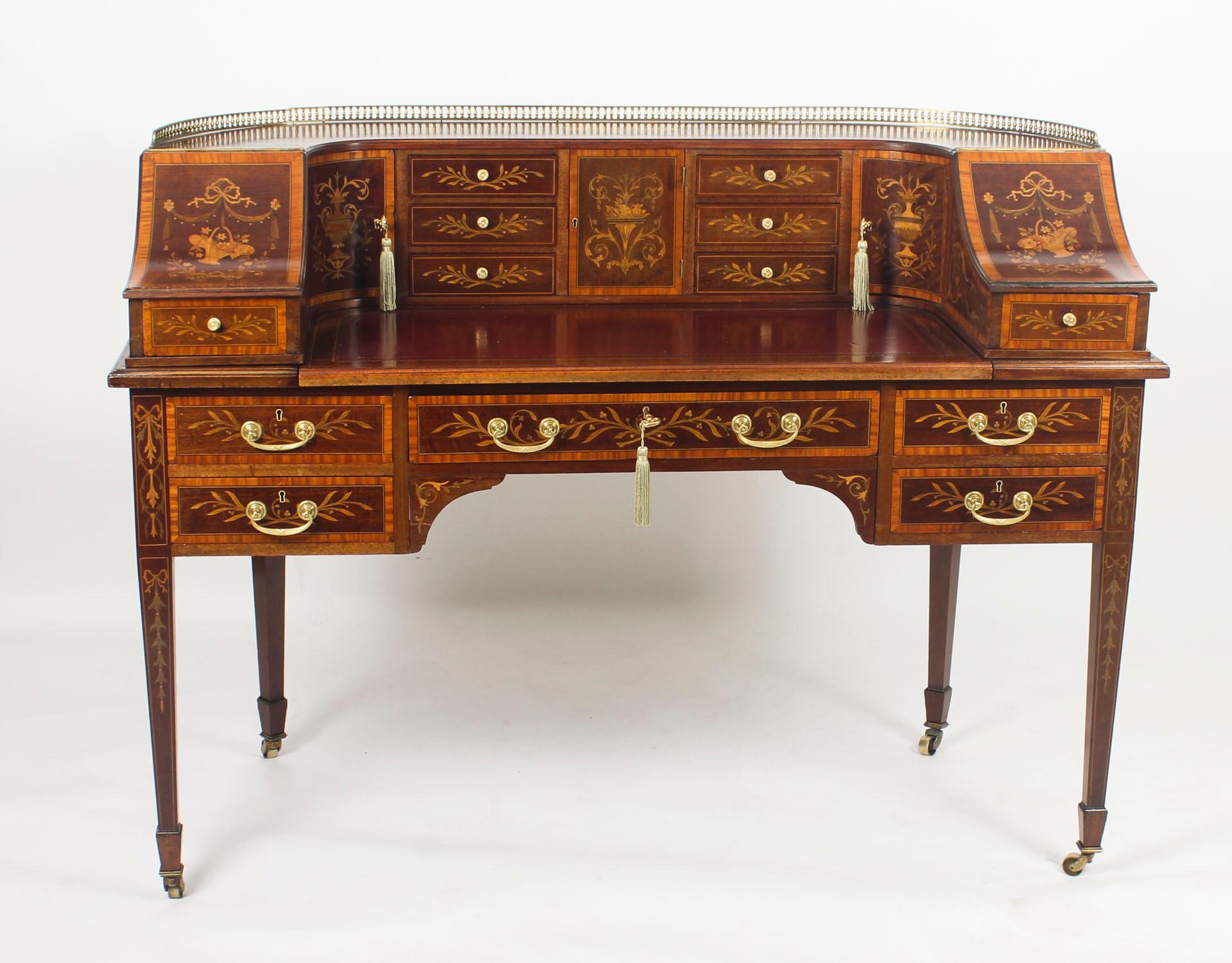 This is a beautiful antique, mahogany, satinwood and marquetry Carlton House writing table by the renowned London retailer and cabinet maker Druce & Co., circa 1880 in date.
 
The top is surmounted with a decorative brass gallery and it is inlaid