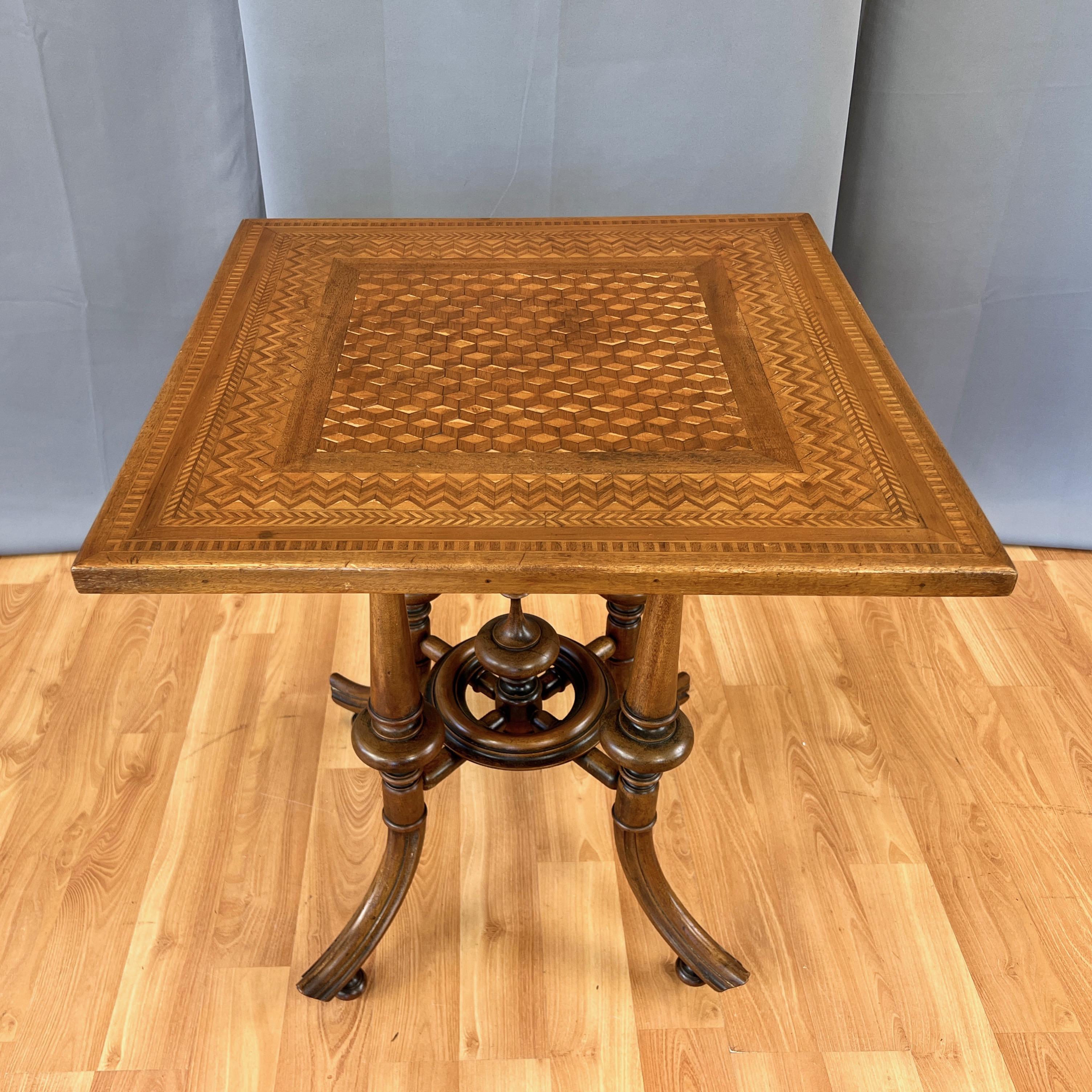 A very well done circa 1900 marquetry top card, game, or occasional table with striking turned wood base.

Fantastic craftsmanship on display from top to bottom, starting with a satinwood and fruitwood veneer marquetry pattern comprised of a field