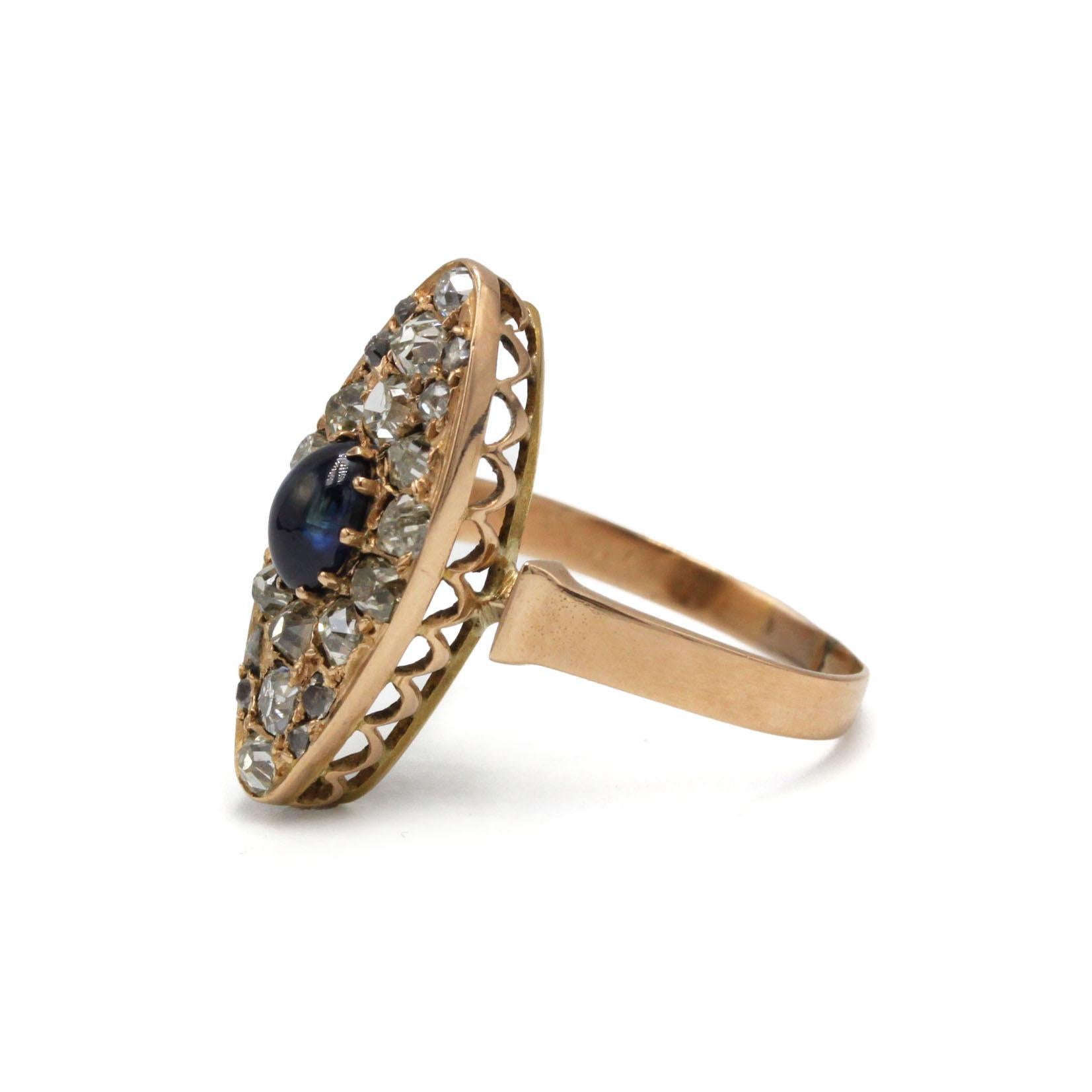 Cette bague marquise ancienne en or 14 carats est sertie d'un saphir bleu captivant en son centre, encadré d'un étincelant groupe de diamants de taille ancienne. Le design allongé en forme de marquise, caractéristique de l'artisanat de la fin du