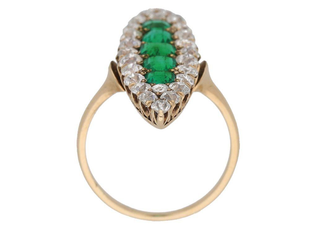 Antique marquise shape emerald and diamond ring. Vertically set with five octagonal emerald-cut natural Muzo emeralds with no colour enhancement in open back grain settings with an approximate combined weight of 2.00 carats, encircled by a single