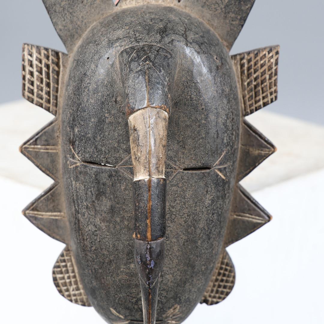 A remarkable rare Baule portrait mask from the Ivory Coast, this finely hand-carved tribal piece captures the essence of traditional West African ritual artistry. Measuring 43 cm in height and 21 cm in width, the mask features a striking composition