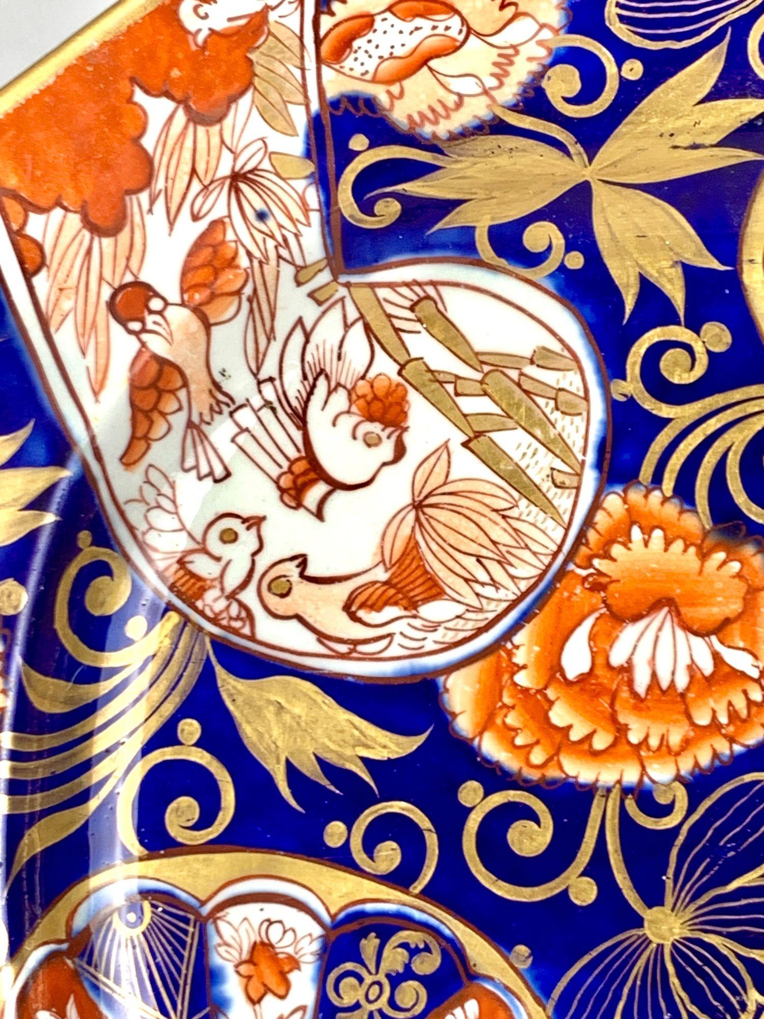 Diese antike Mason's Ironstone-Platte wurde um 1820 in England hergestellt und weist eine lebhafte Dekoration in der Imari-Farbpalette von Kobaltblau, Eisenrot und reicher Vergoldung auf.
Die zentralen Paneele wechseln zwischen floralen Rondellen