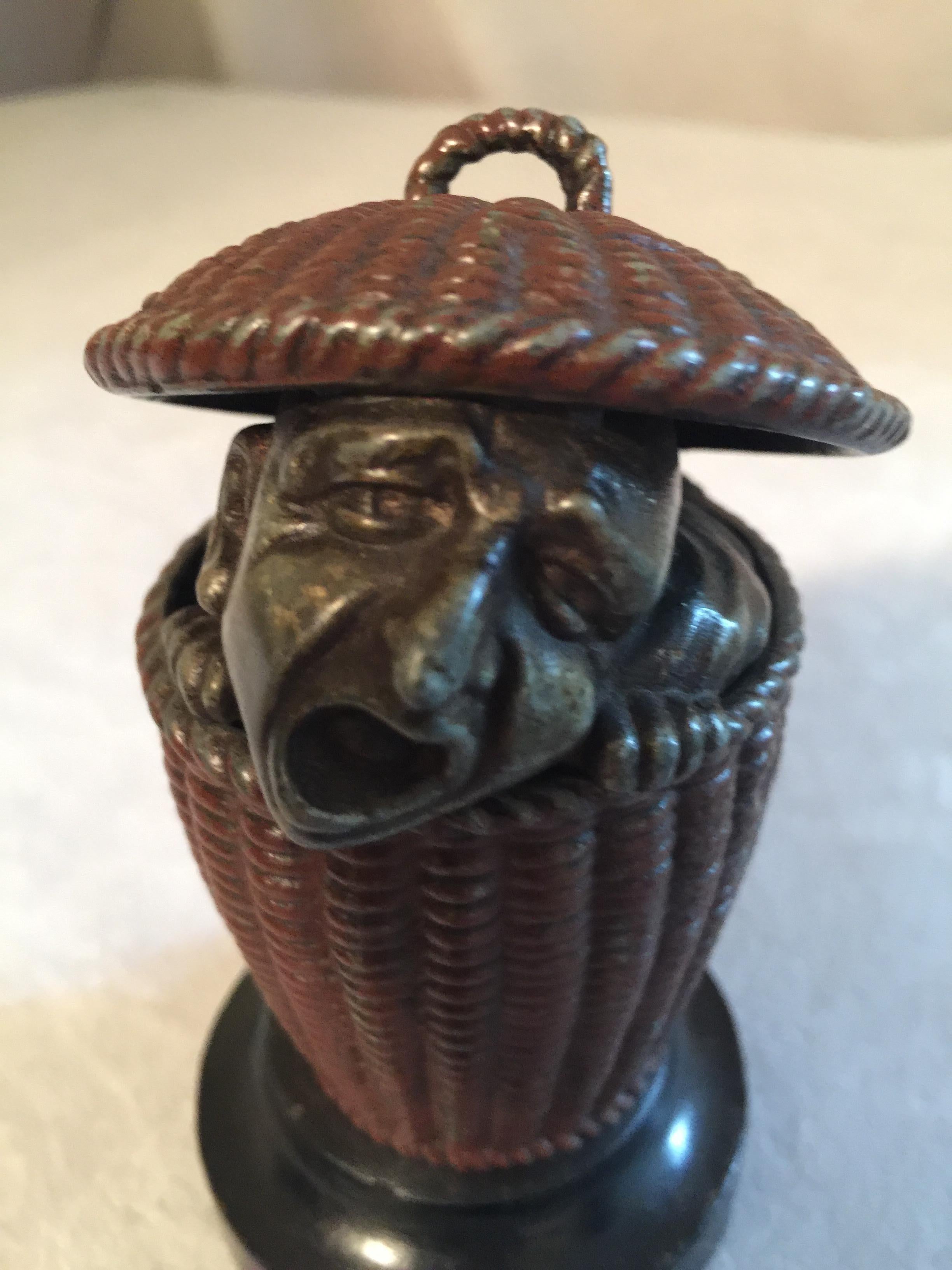 This most unusual match safe features this poor fellow peeking out of a basket that will hold your matches. I should think the match safe is the least important characteristic of this item. His face is quite fascinating and whimsical. I don't