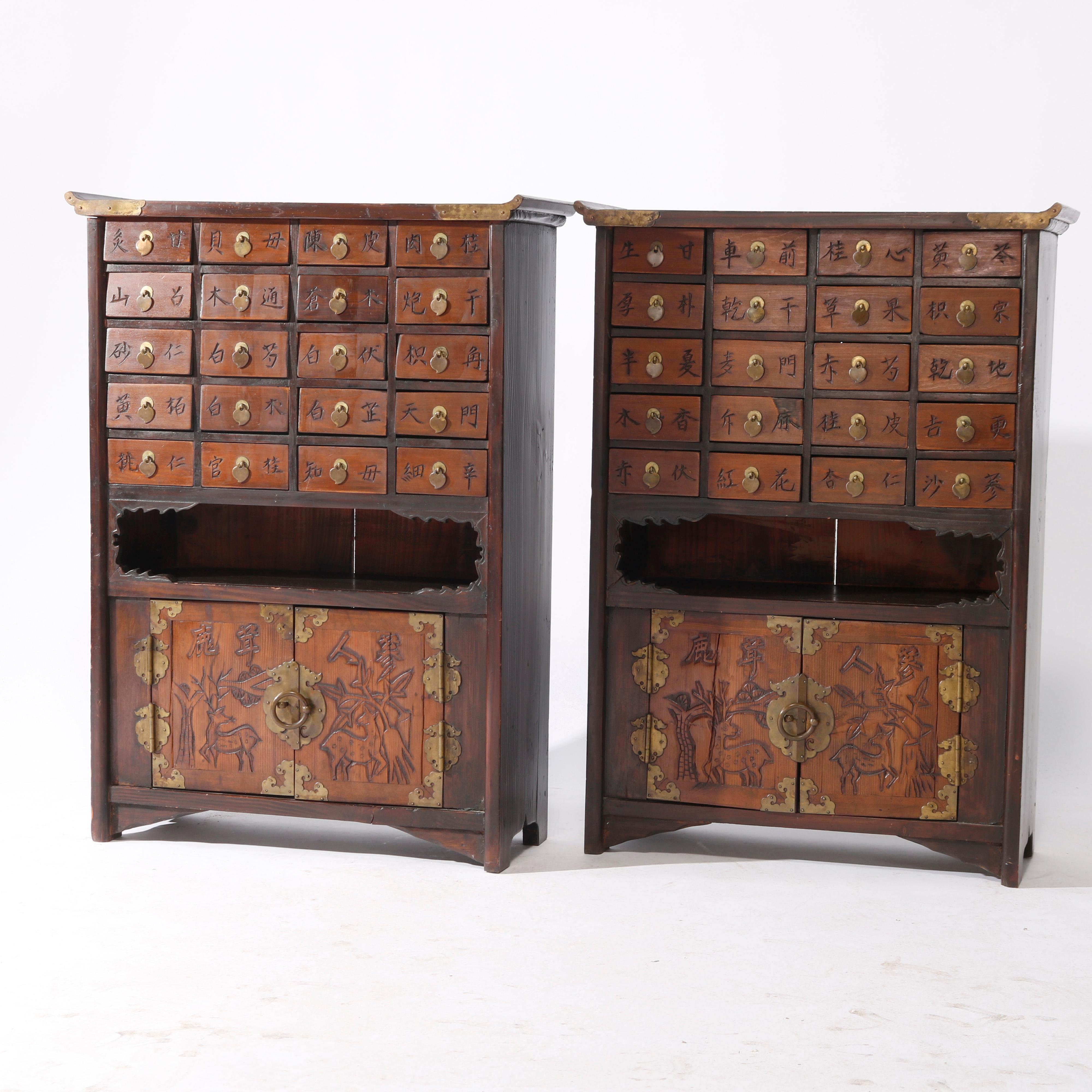 An antique pair of matching Chinese spice cabinets offers hardwood construction with twenty upper drawers each having chop mark characters over lower cabinet having double doors with carved deer scene, c1930

Measures - 29'' H X 21'' W X 8.75''