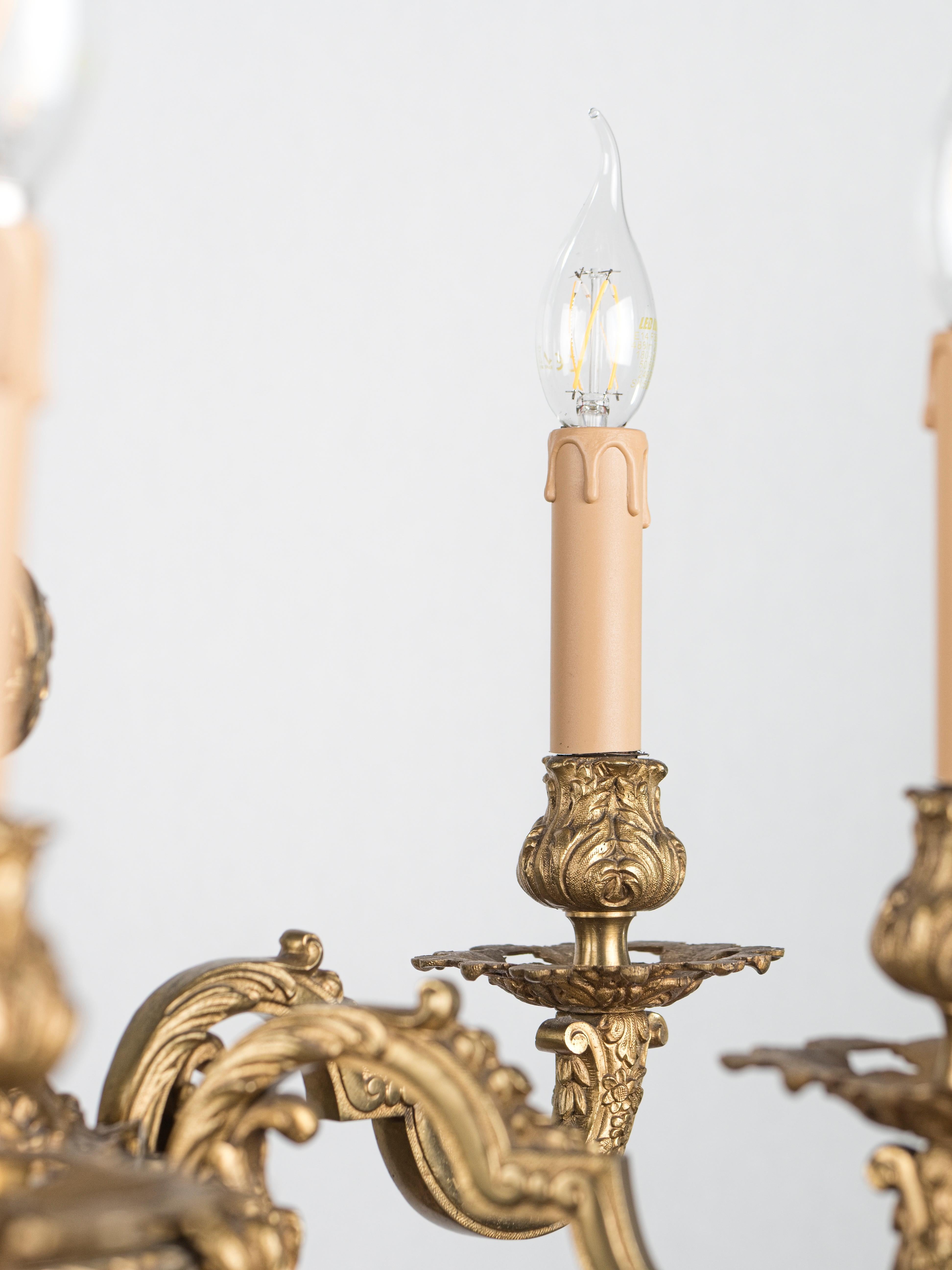 Un luxueux lustre en bronze doré antique avec une riche décoration florale. Le lustre est restauré : nouveau câble d'alimentation, nouvelles nacelles, prises d'origine - entièrement fonctionnel - prêt à l'emploi. Le lustre est prévu pour 6 ampoules