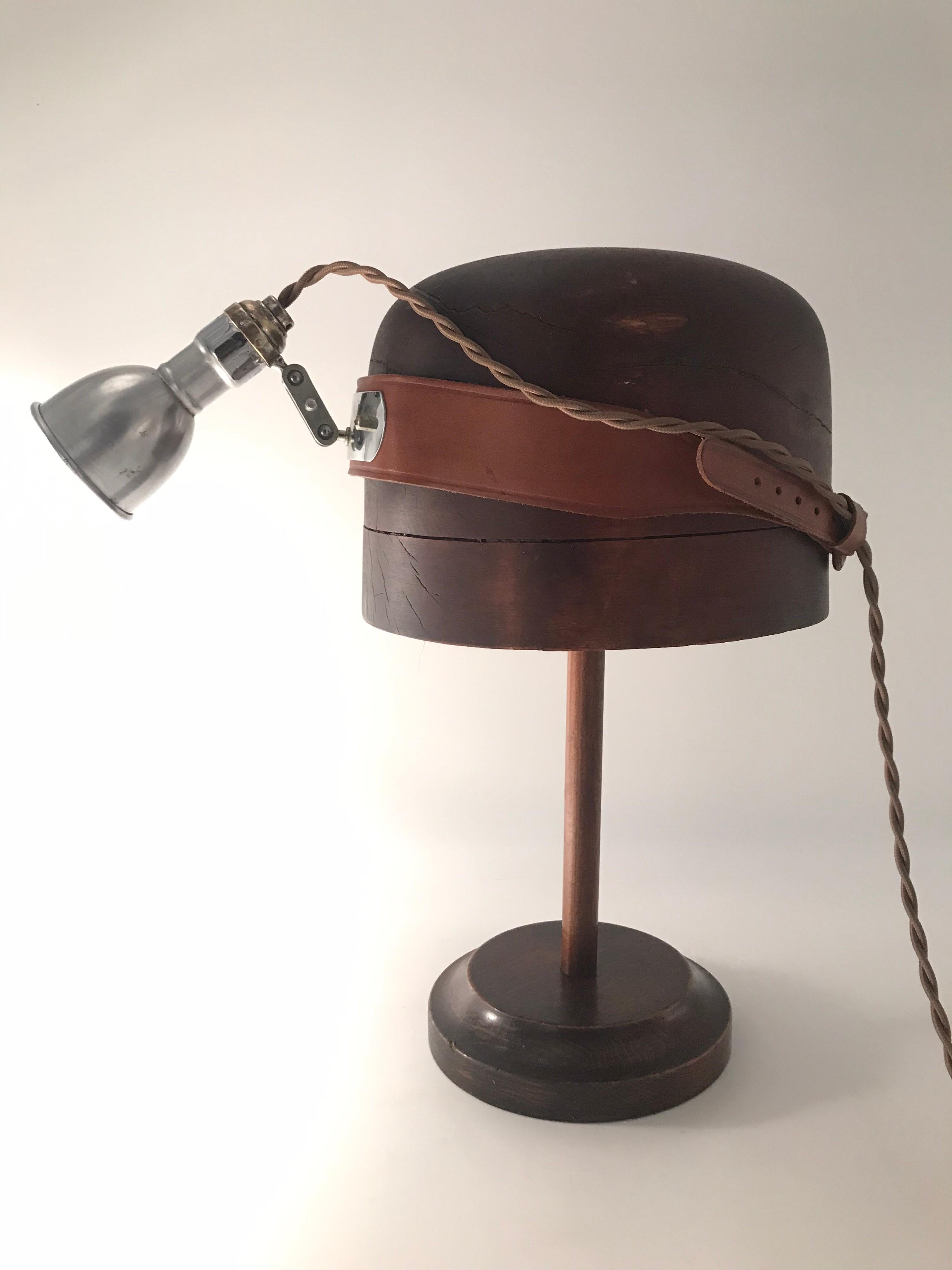 Antique medical head lamp display stand 
In working order as a table lamp 
Lovely patina to all the surfaces on the brass, wood and leather 
6cm pressed aluminum shade 
New wiring 
Such an original piece of lighting history that can be put