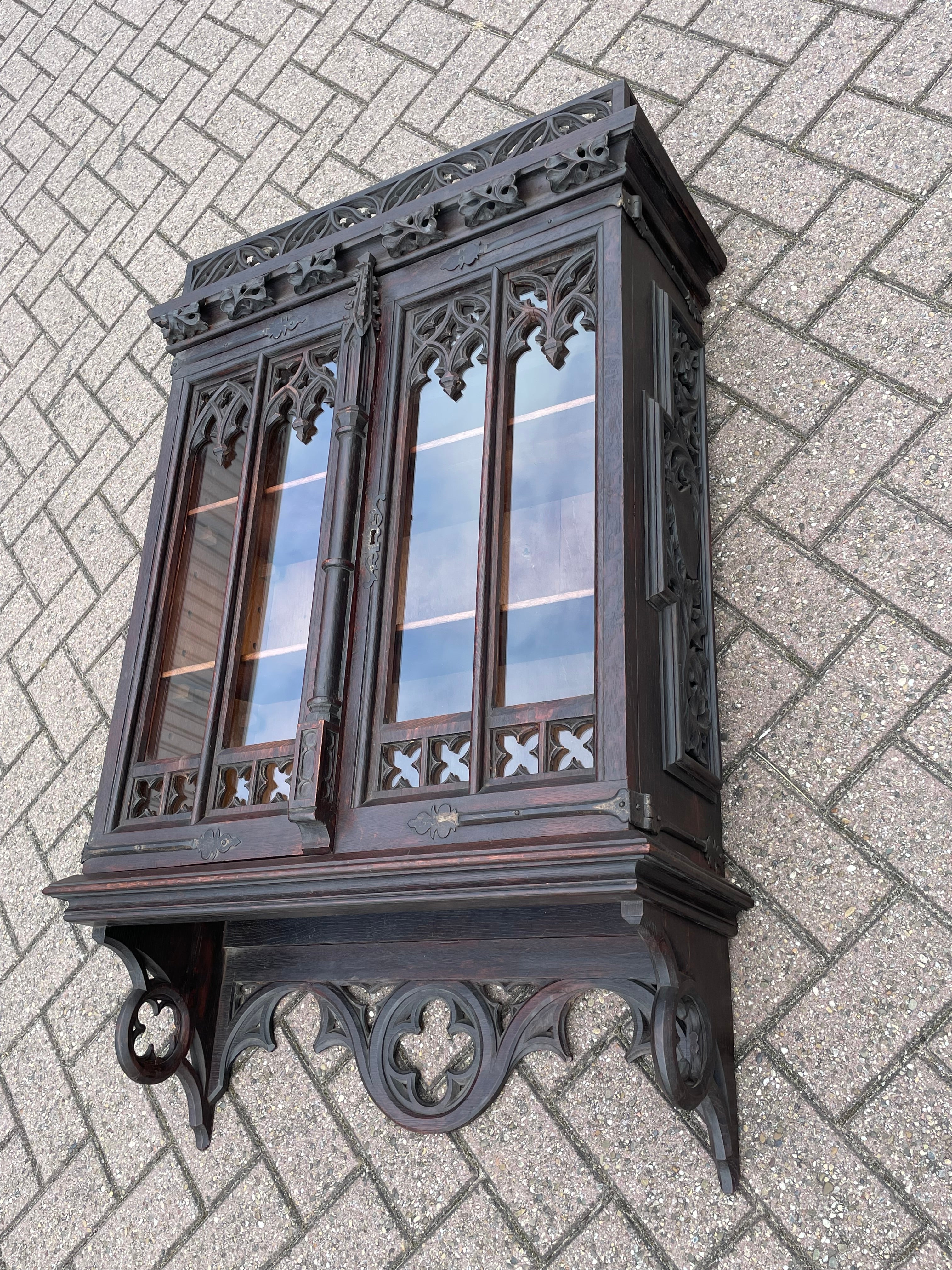 Unique and amazing wall cabinet with Gothic church window paneled doors and more.

This handcrafted and rare Gothic Revival wall cabinet from the late 1800s is another one of our magnificent finds. The size, the quality of the make and the multitude