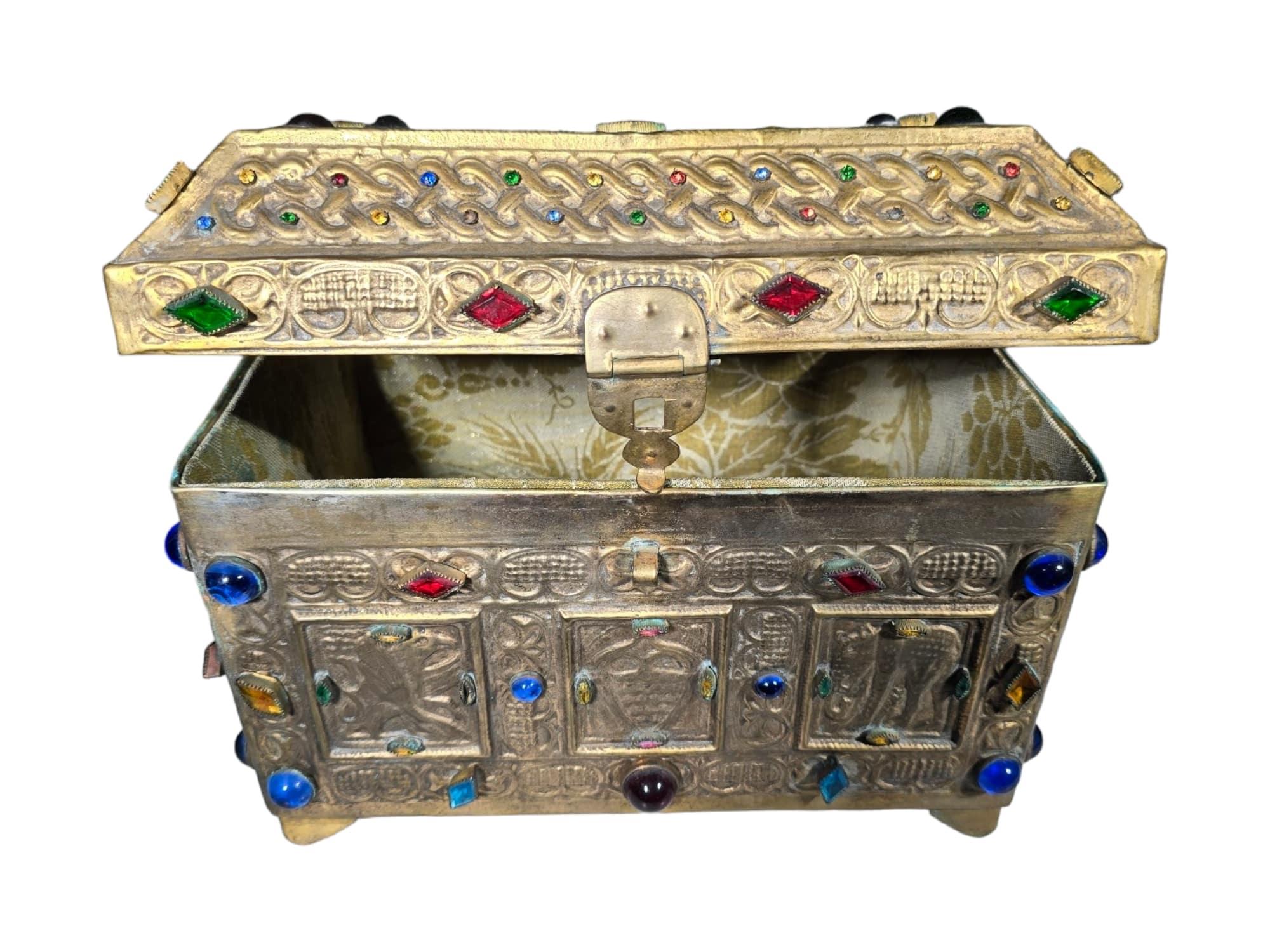 Questa affascinante cassapanca, risalente ai primi anni del 1900, è realizzata in stile medievale e presenta un bronzo dorato con intarsi in vetro. Il design intricato e la lavorazione dettagliata lo rendono un pezzo sorprendente che cattura