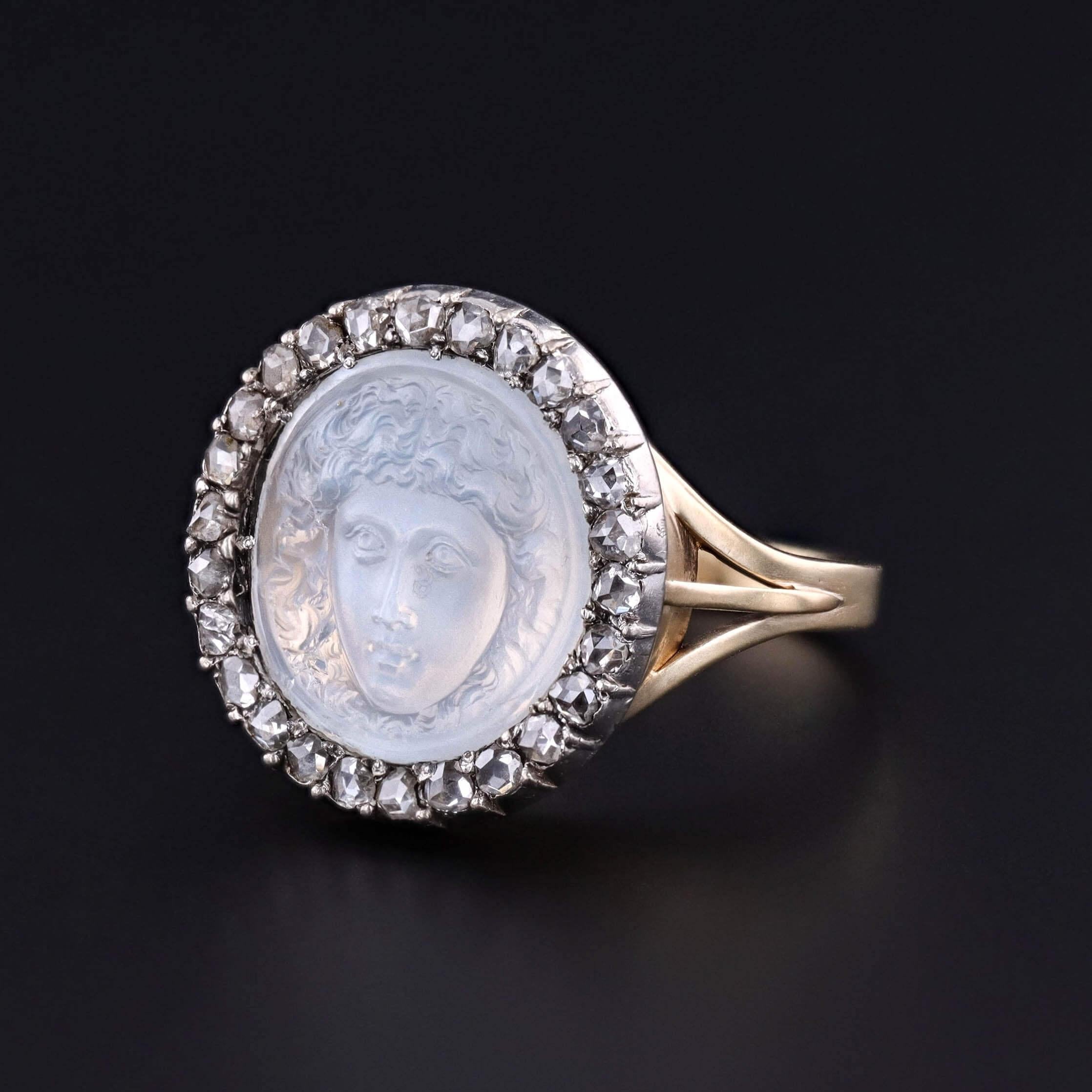 Un fascinante anillo antiguo con un camafeo de Medusa tallado en piedra de luna de ortoclasa, con rasgos de una translucidez luminosa y una intensidad mítica. El camafeo está enmarcado por un halo resplandeciente de diamantes talla rosa engastados