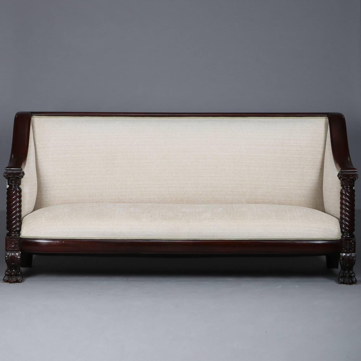 Antique Meeks School American Empire Classical upholstered carved mahogany sofa features arms with full barley twist column supports above floral carved die joints and seated on acanthus decorated paw feet, circa 1840

Measures: 41