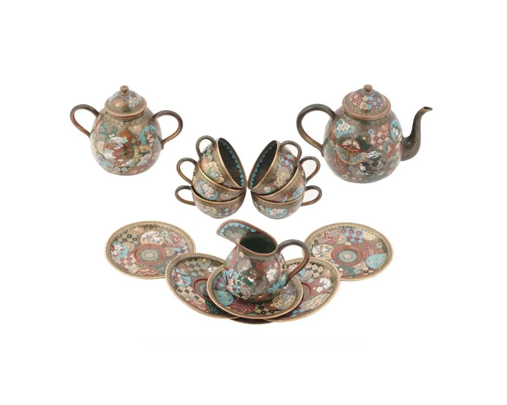 A superb antique Japanese cloisonne enamel tea set from the Meiji Era, 1868 to 1912. The set comprises 6 teacups and saucers, a teapot, a sugar bowl and a creamer decorated with fine enamels depicting traditional Japanese shippo patterns, floral