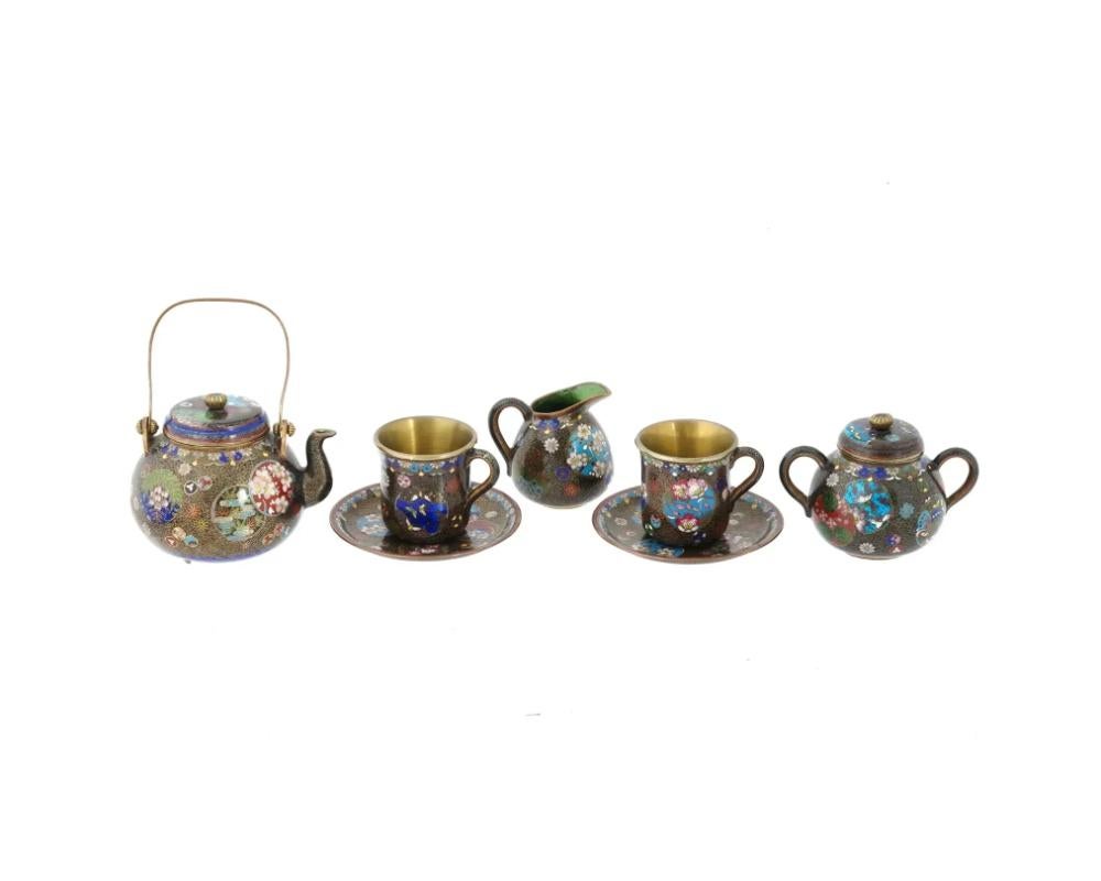 Antiguo juego de té japonés de esmalte cloisonné de la Era Meiji, de 1868 a 1912. Un total de 7 elementos. El juego consta de 2 tazas y platillos, una tetera, un azucarero y una cremera decorados con finos esmaltes que representan mariposas,