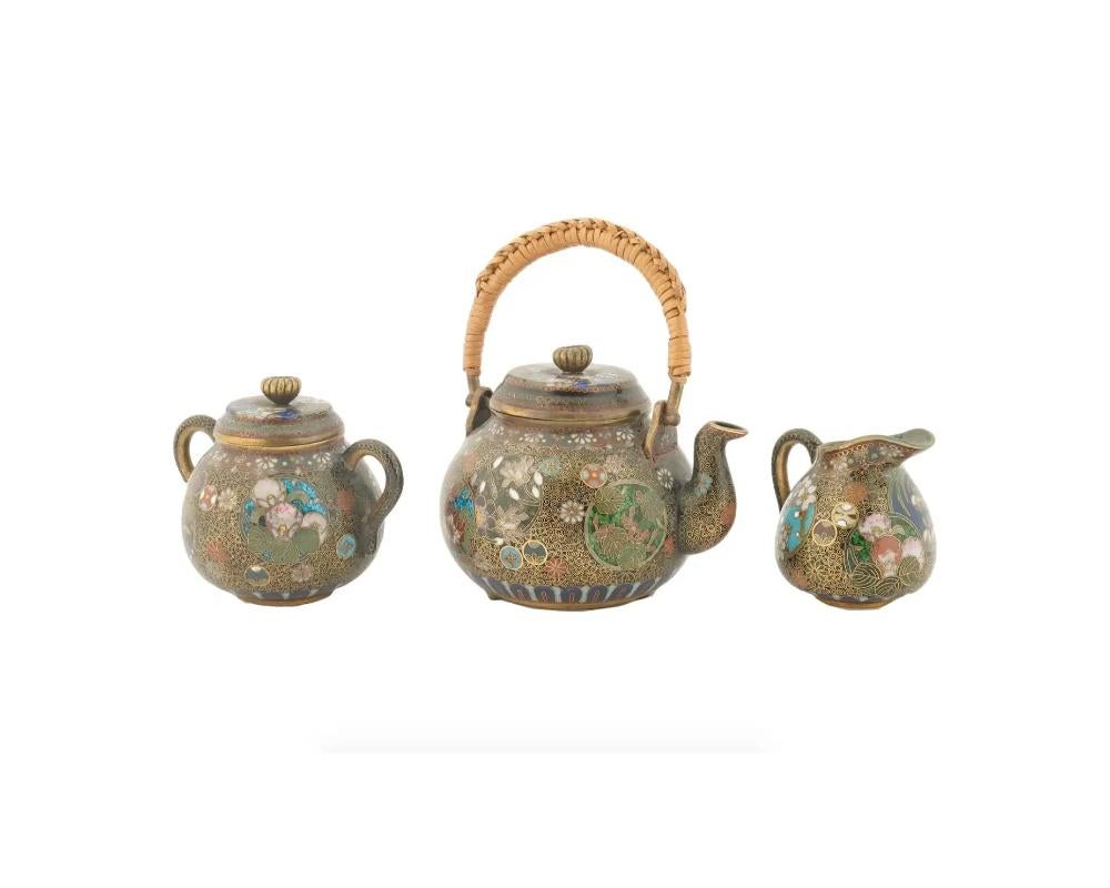 Superbe service à thé japonais ancien en émail cloisonné de l'ère Meiji, 1868 à 1912. L'ensemble comprend 2 tasses et soucoupes, une théière, un sucrier et un crémier décorés de fins émaux représentant des papillons, des arrangements floraux et des