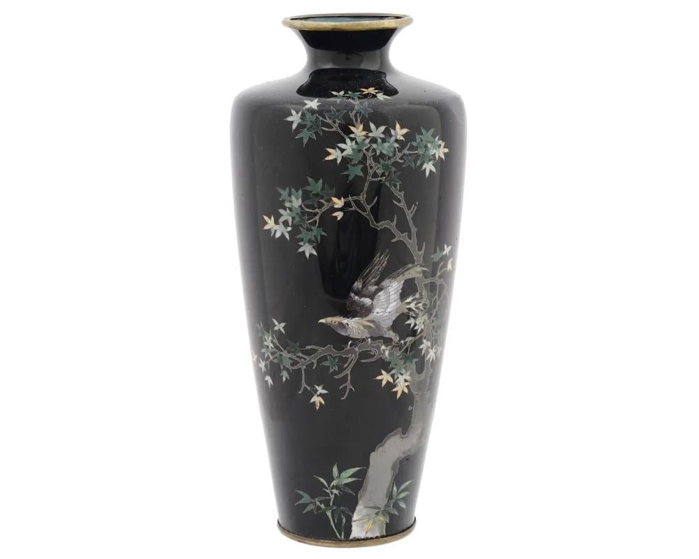 An antique Japanese Meiji Era brass and enamel vase. Circa: early 20th century. The baluster form vase is enameled with a polychrome image of an eagle sitting on a tree made in the Cloisonne technique on a black ground. Unmarked. Antique and Vintage