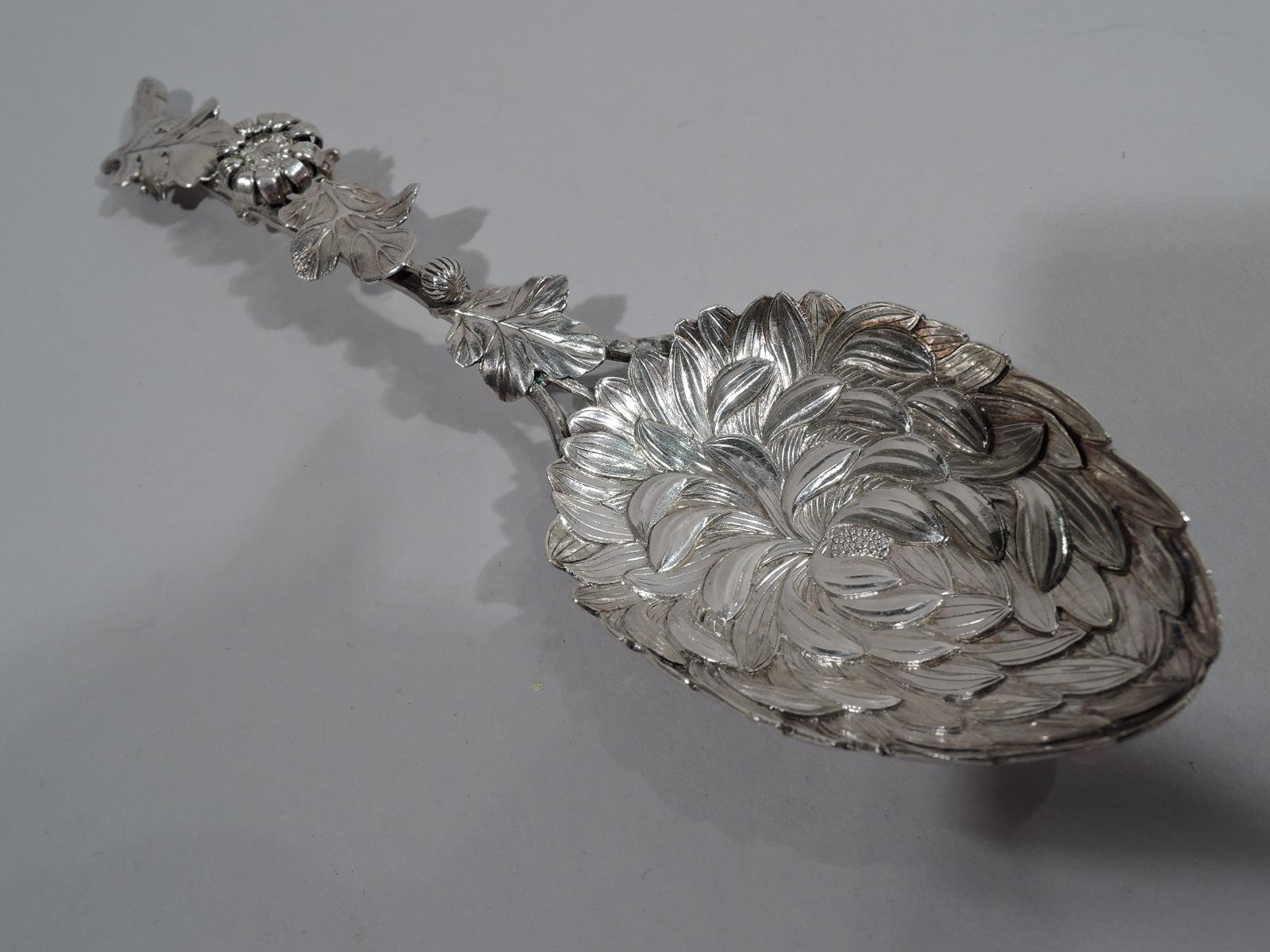 Meiji-era silver Chrysanthemum serving spoon, circa 1880. Oval flower head bowl with chased petals and serrated rim. Stem handle with applied buds and leaves, and irregular pronged terminal. Modish Japanese Japonisme. Marked “Sterling”. Weight: 2