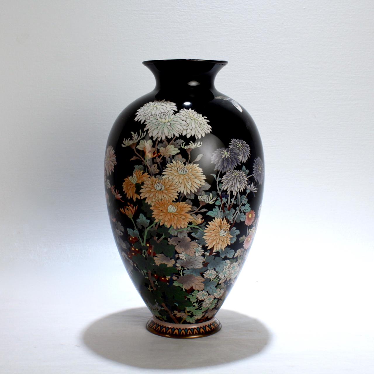 A large antique Japanese cloisonné vase.

With blooming chrysanthemums, daisies, and butterflies on a black ground. 

Meiji period. 

Measures: Height ca. 12 in.

   




     