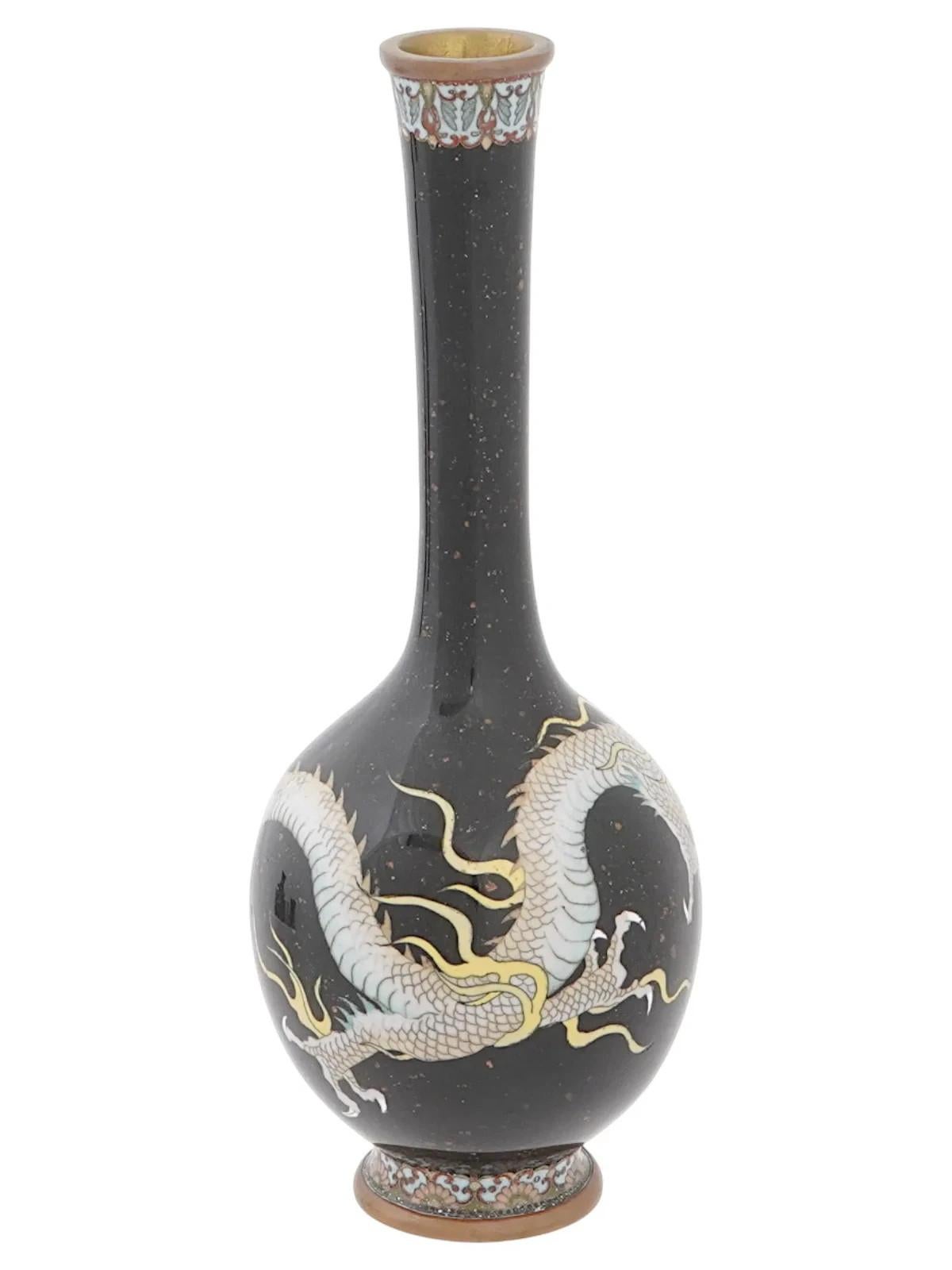 Vase en émail chinois. Le vase a un corps de forme globulaire avec un long col étroit et une bouche cannelée. L'extérieur de la vaisselle est orné d'un motif en émail polychrome représentant un dragon sur un fond sombre, réalisé selon la technique