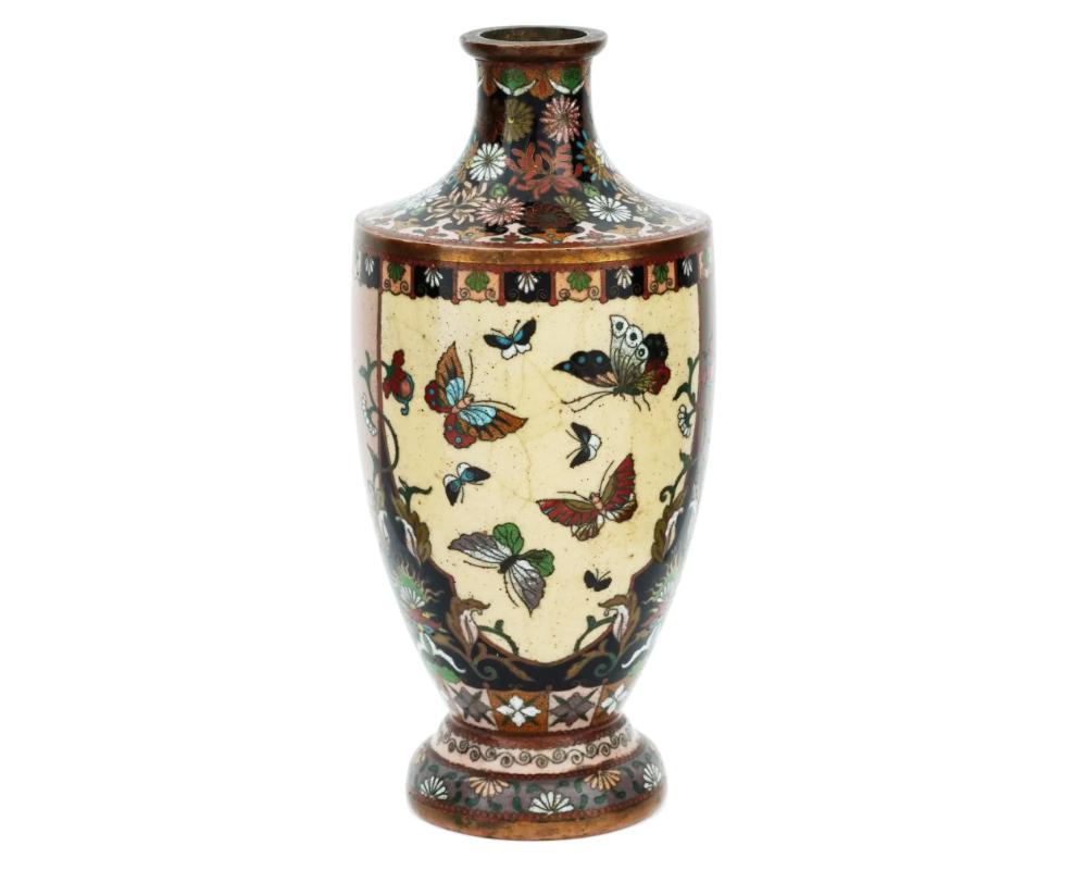 Vaso giapponese d'epoca a forma di urna, smaltato su rame. L'esterno del vaso è ornato da pannelli smaltati a mano che raffigurano farfalle, gru, un uccello Phoenix, circondati da ornamenti floreali, volute e volute realizzate con la tecnica